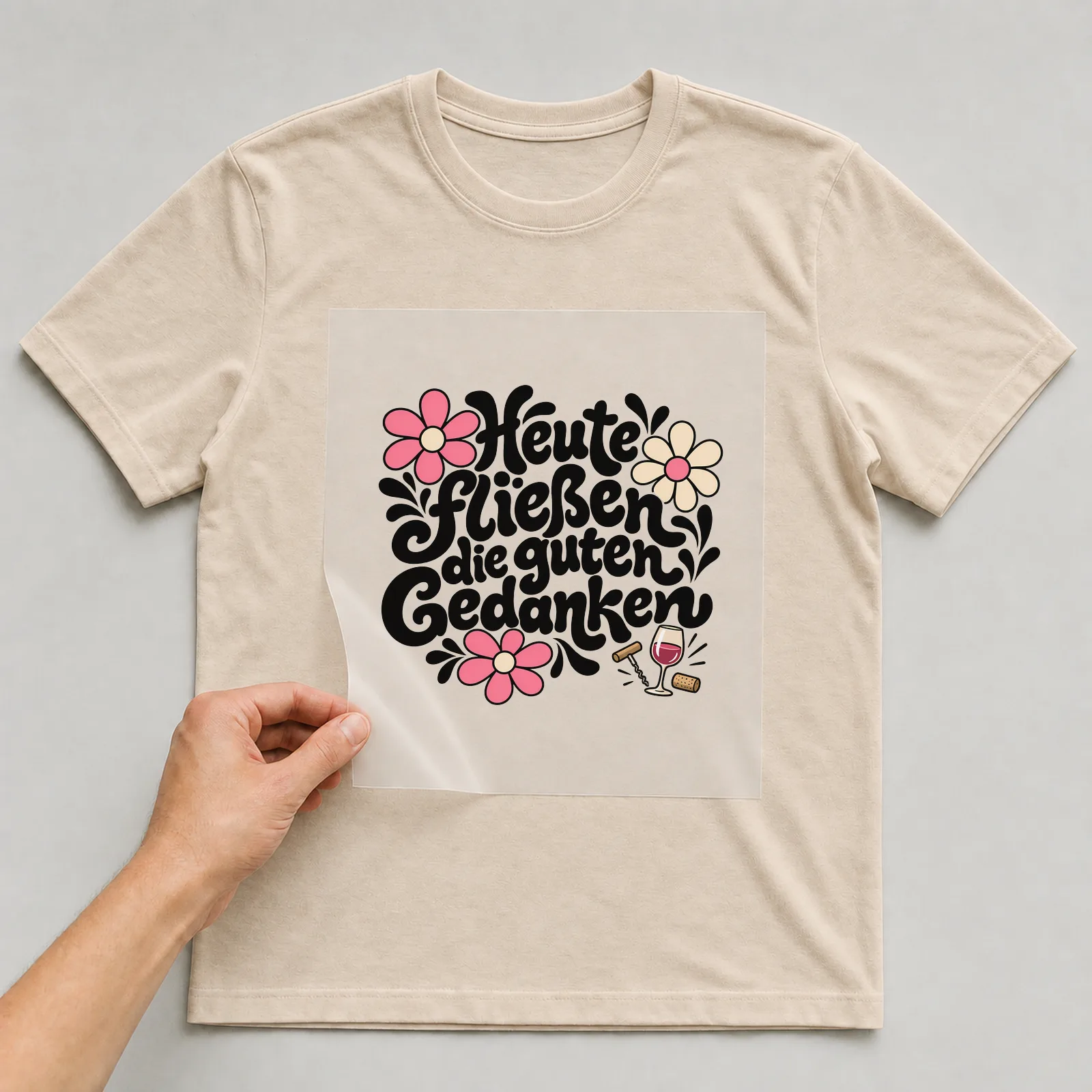 Bügelbild „Heute fließen die guten Gedanken“ auf beigem T-Shirt, Folie wird aufgelegt