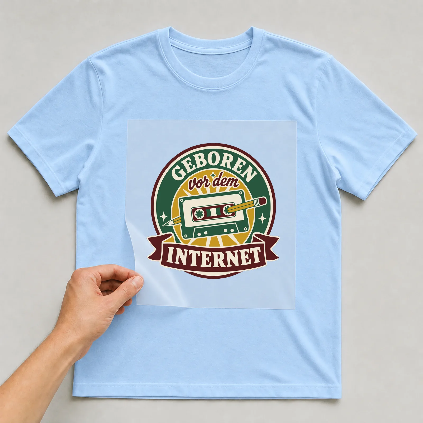 Bügelbild Geboren vor dem Internet auf hellblauem T-Shirt, Folie wird aufgelegt