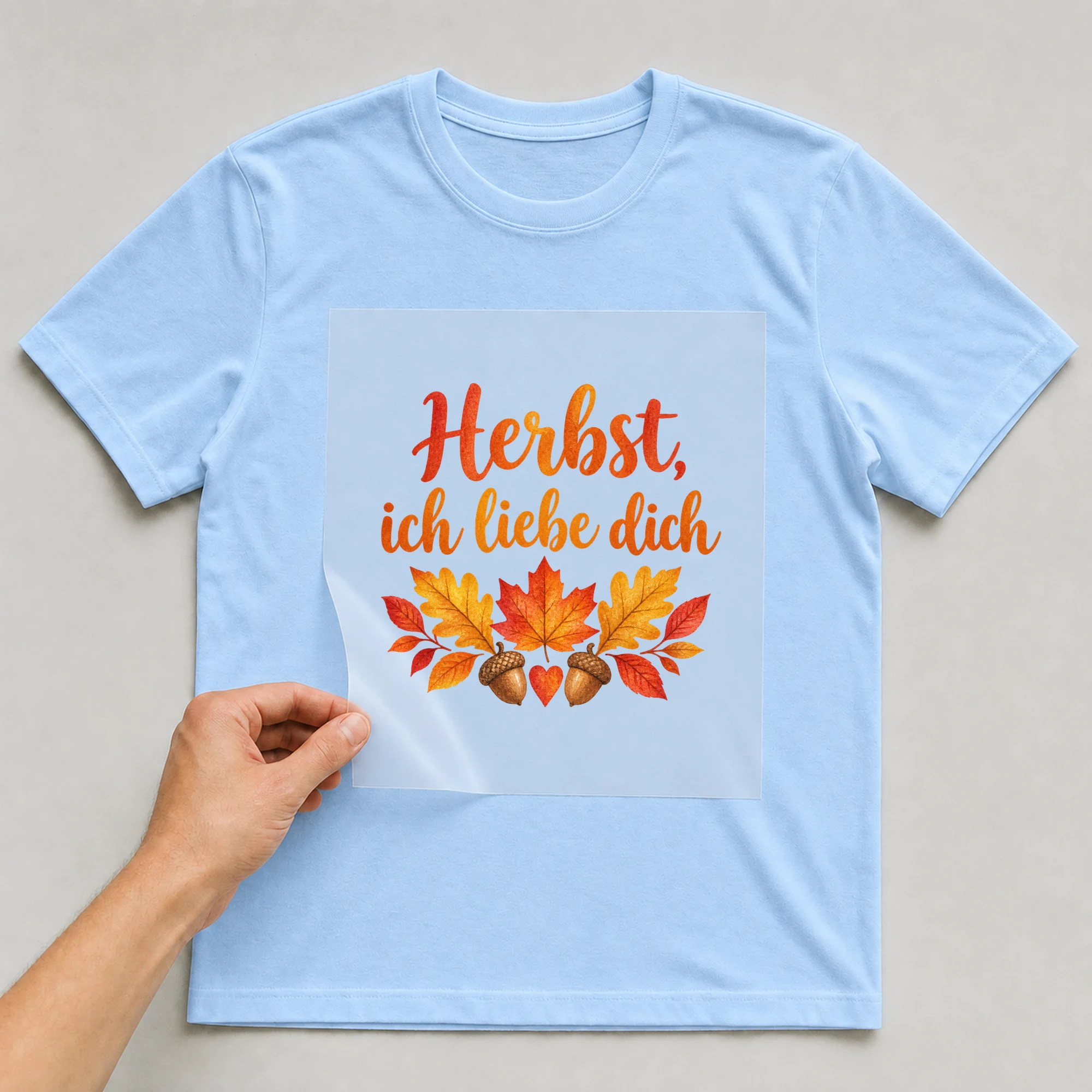 Bügelbild „Herbst, ich liebe dich“ auf babyblauem T-Shirt, Folie wird aufgelegt