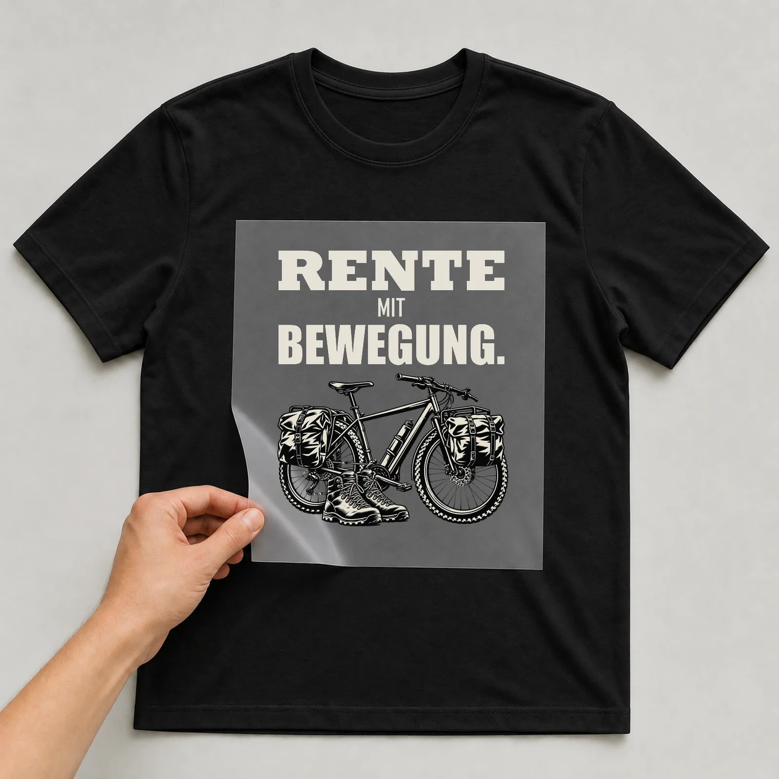 Bügelbild „Rente mit Bewegung“ auf schwarzem T-Shirt, Folie wird aufgelegt