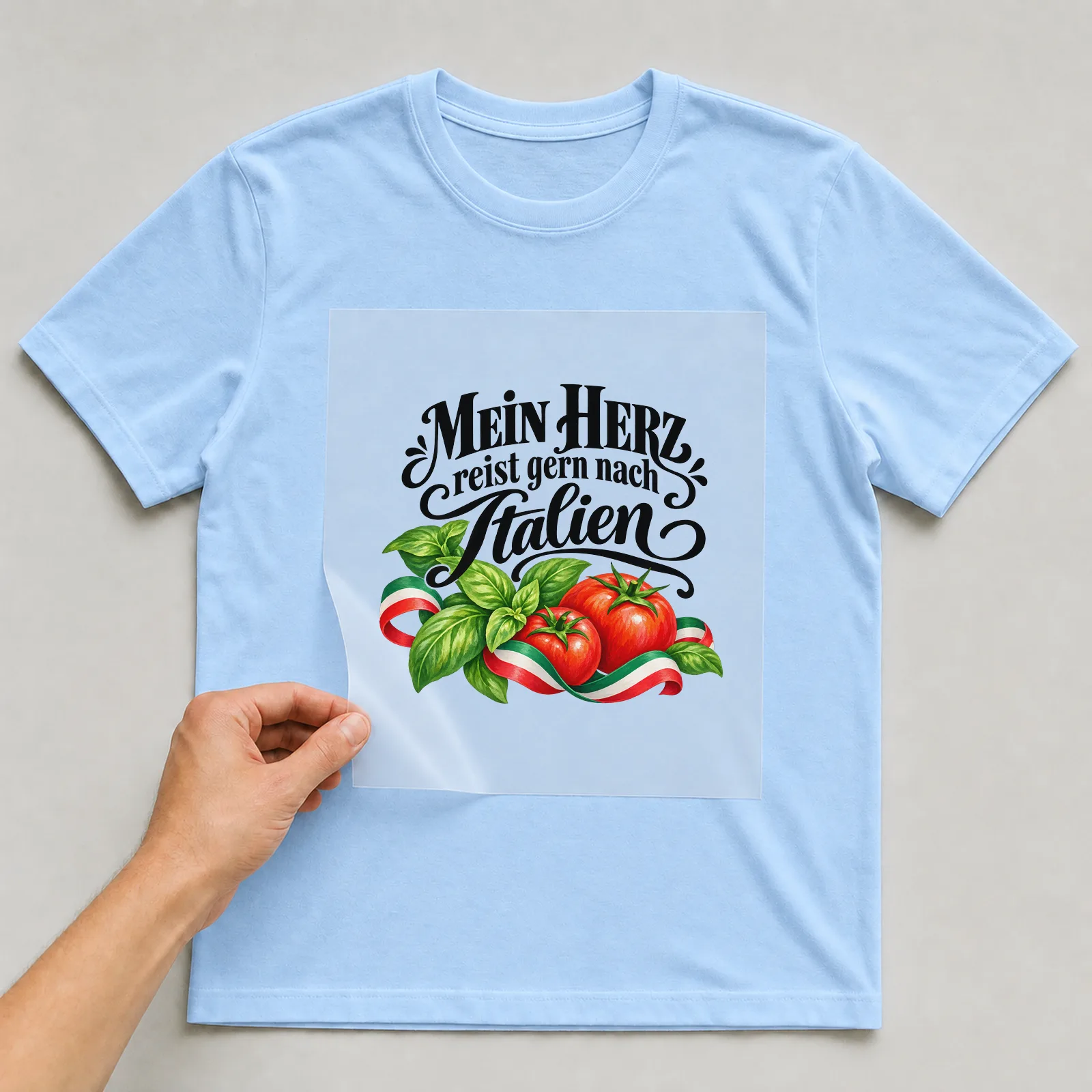 Bügelbild „Mein Herz reist gern nach Italien“ auf hellblauem T-Shirt, Folie wird aufgelegt