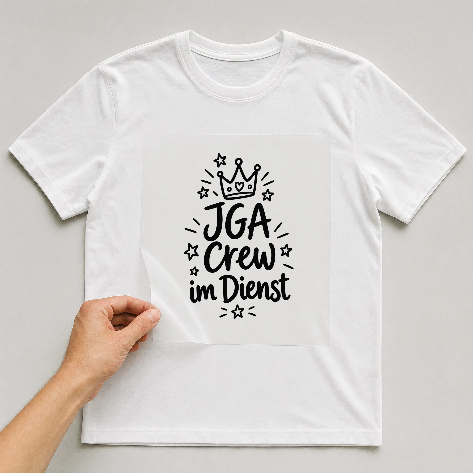 Bügelbild „JGA Crew im Dienst“ auf weißem T-Shirt, Folie wird aufgelegt