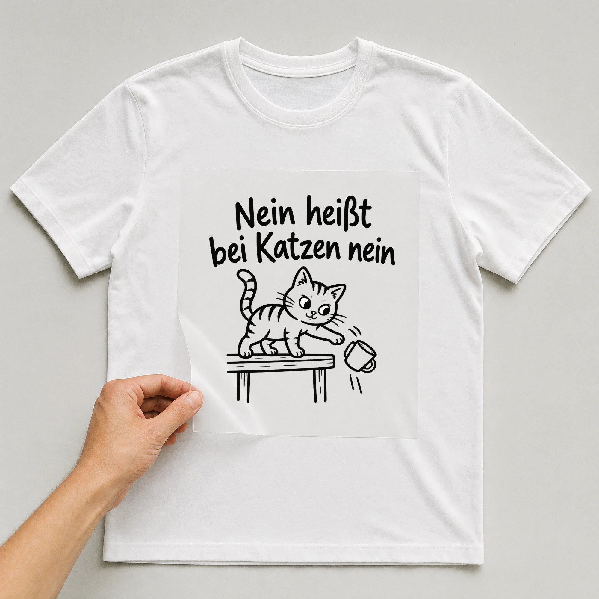 Bügelbild „Nein heißt bei Katzen nein“ auf weißem T-Shirt, Folie wird aufgelegt
