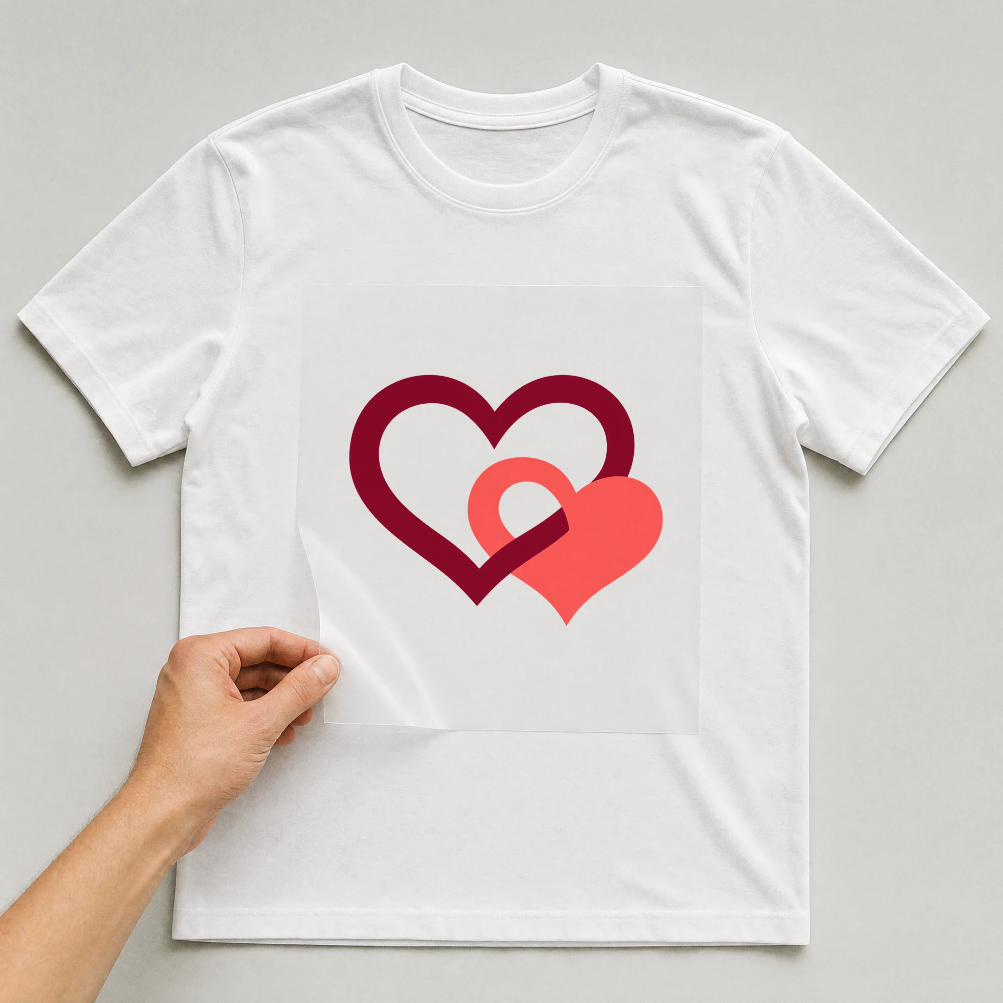 Bügelbild „Zwei Herzen mit 2“ auf weißem T-Shirt, Folie wird aufgelegt