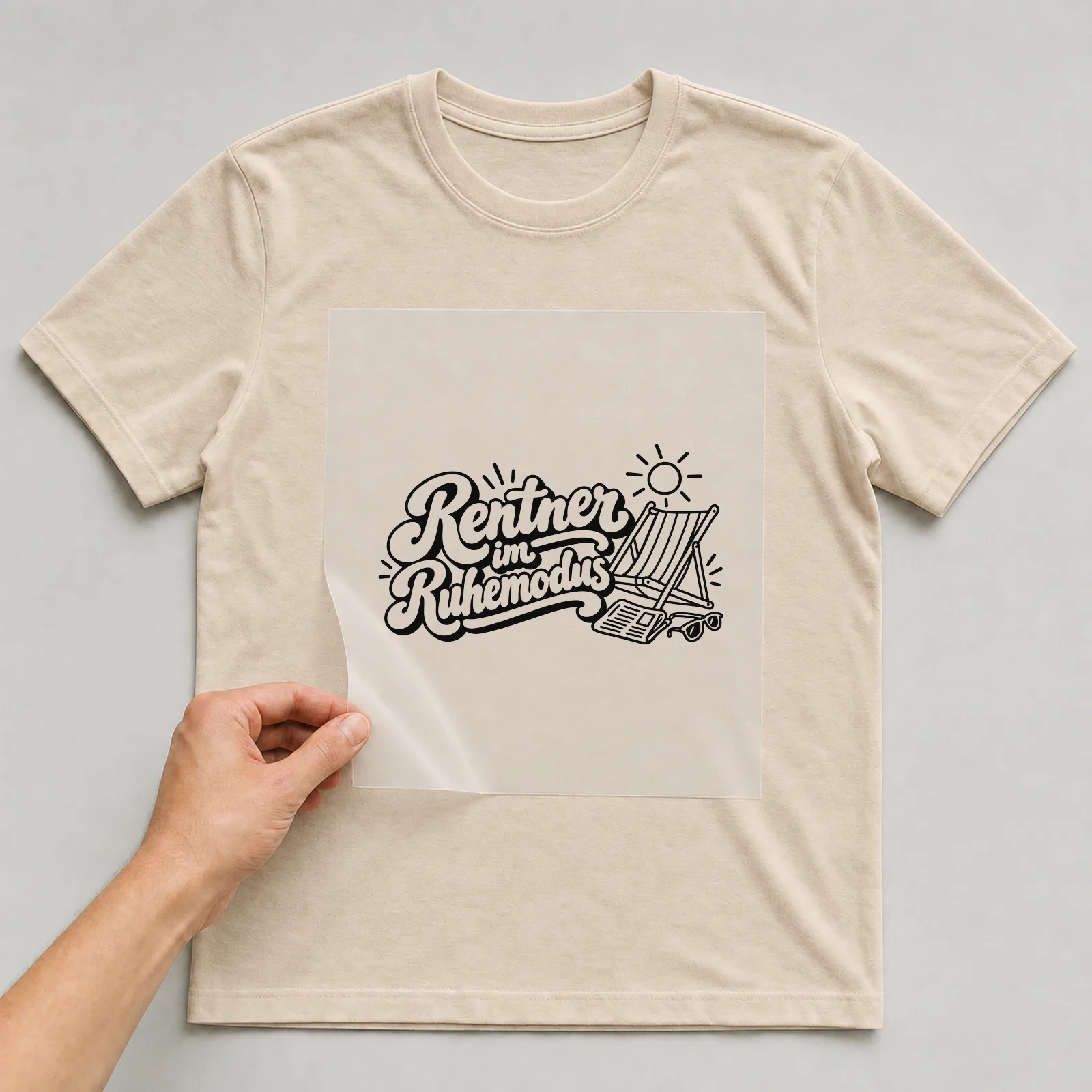 Bügelbild „Rentner im Ruhemodus“ auf beigem T-Shirt, Folie wird aufgelegt