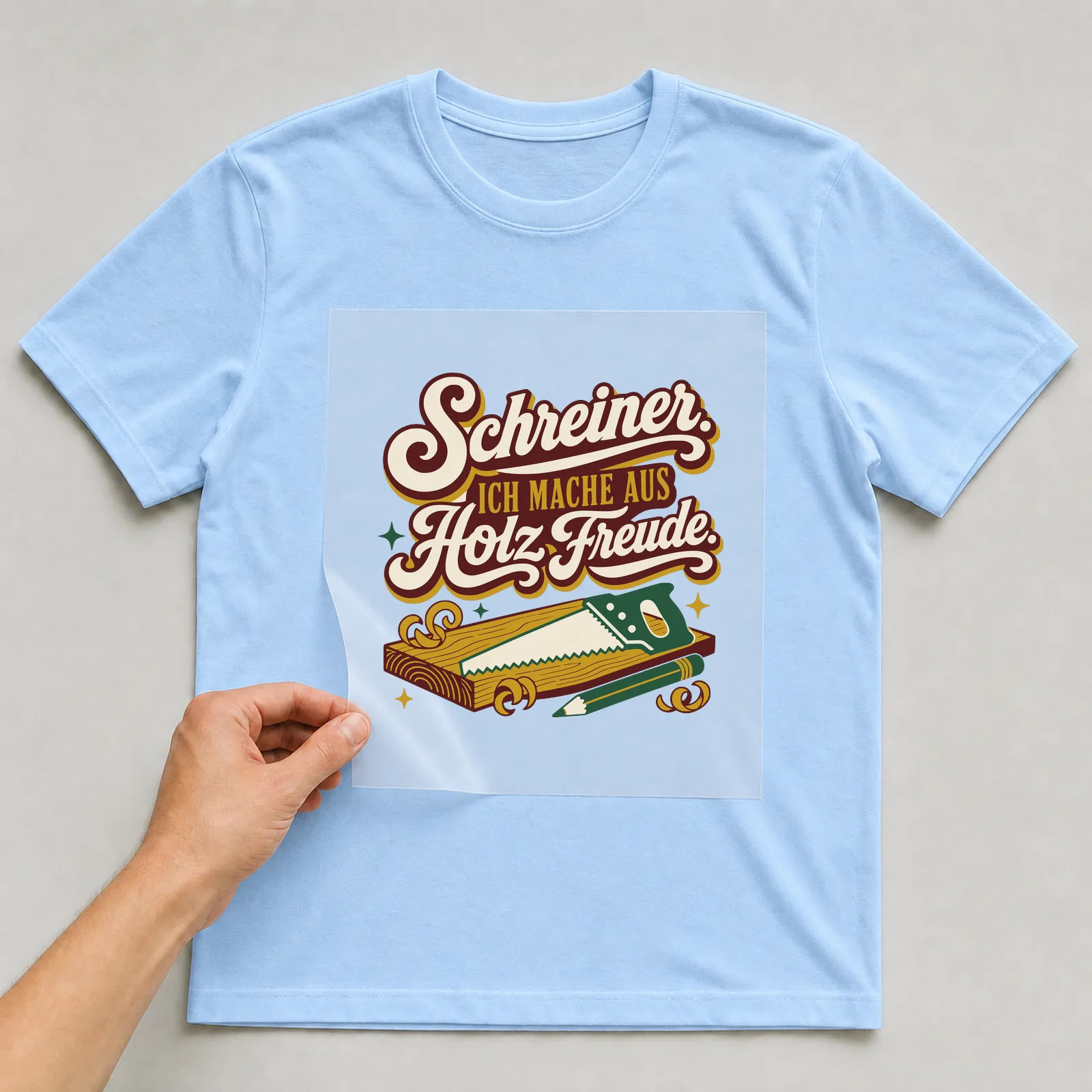 Bügelbild Schreiner. Ich mache aus Holz Freude. auf hellblauem T-Shirt, Folie wird aufgelegt