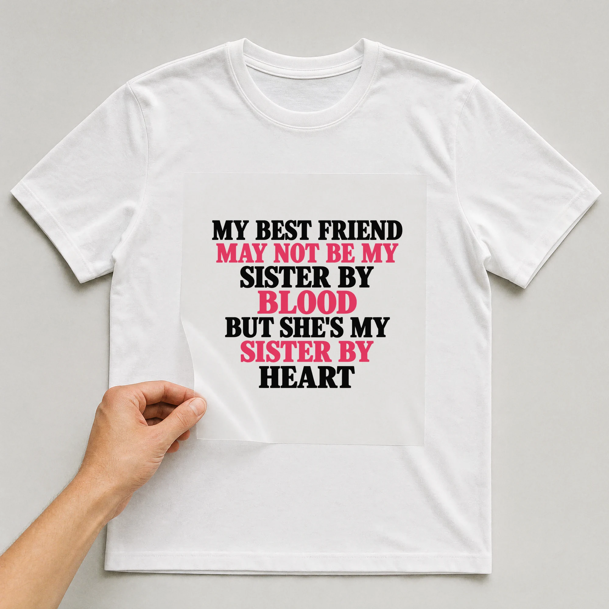 Bügelbild „My Best Friend May Not Be My Sister By Blood But She's My Sister By Heart“ auf weißem T-Shirt, Folie wird aufgelegt