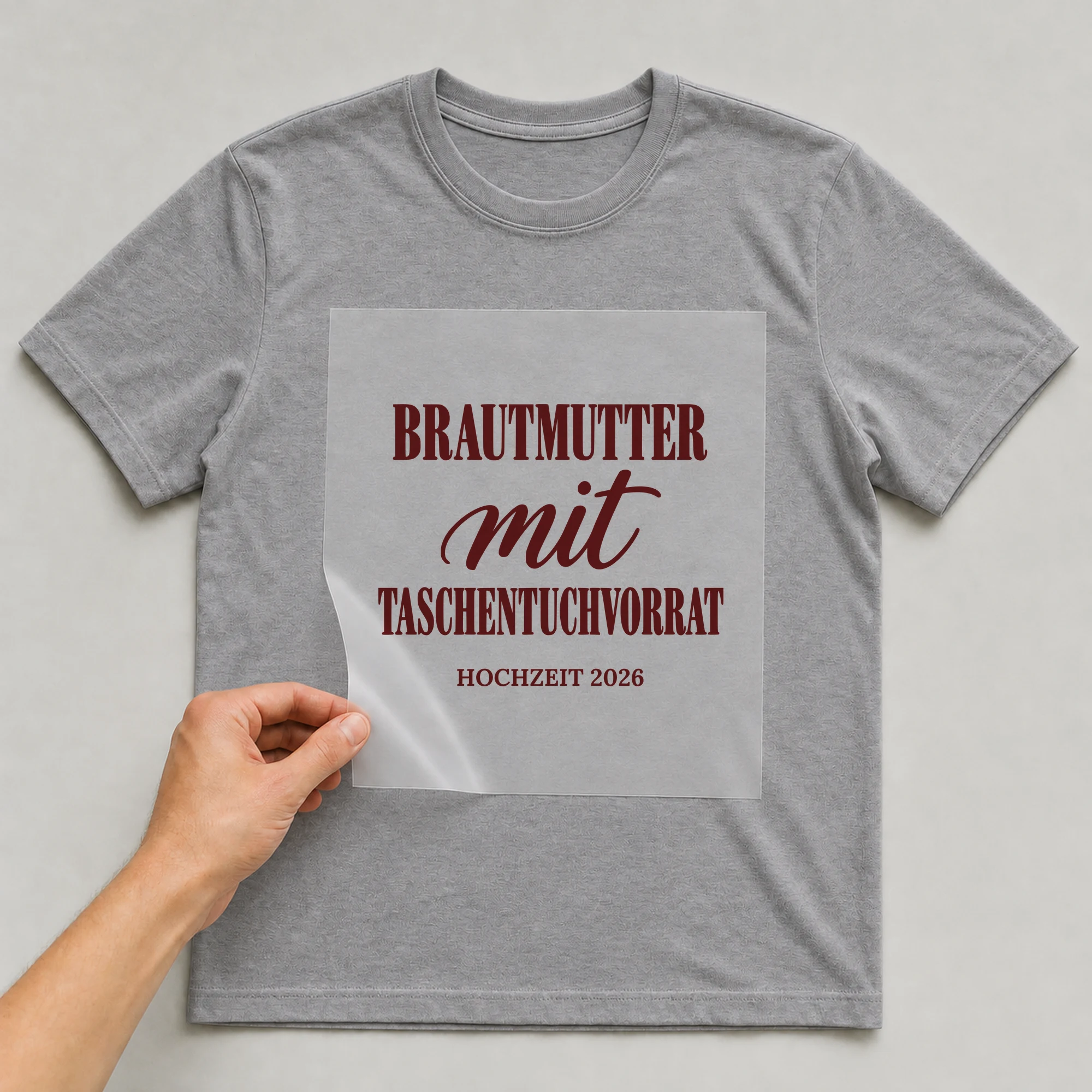 Bügelbild Brautmutter mit Taschentuchvorrat mit Jahr auf grauem T-Shirt, Folie wird aufgelegt