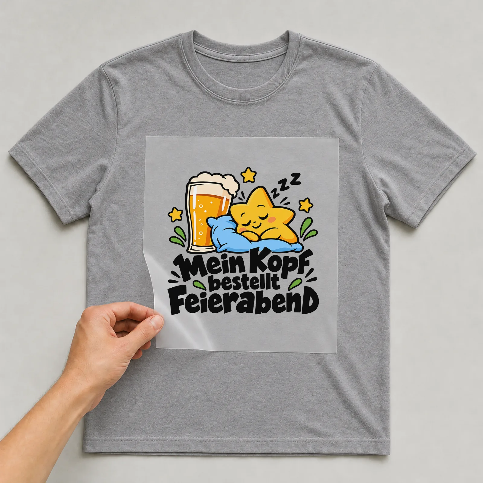 Bügelbild „Mein Kopf bestellt Feierabend“ auf grauem T-Shirt, Folie wird aufgelegt