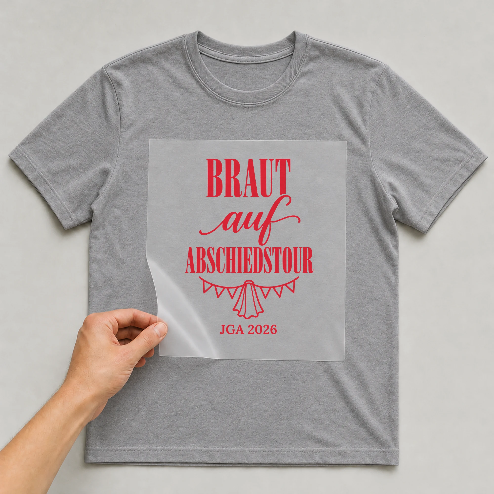 Bügelbild Braut auf Abschiedstour auf grauem T-Shirt, Folie wird aufgelegt