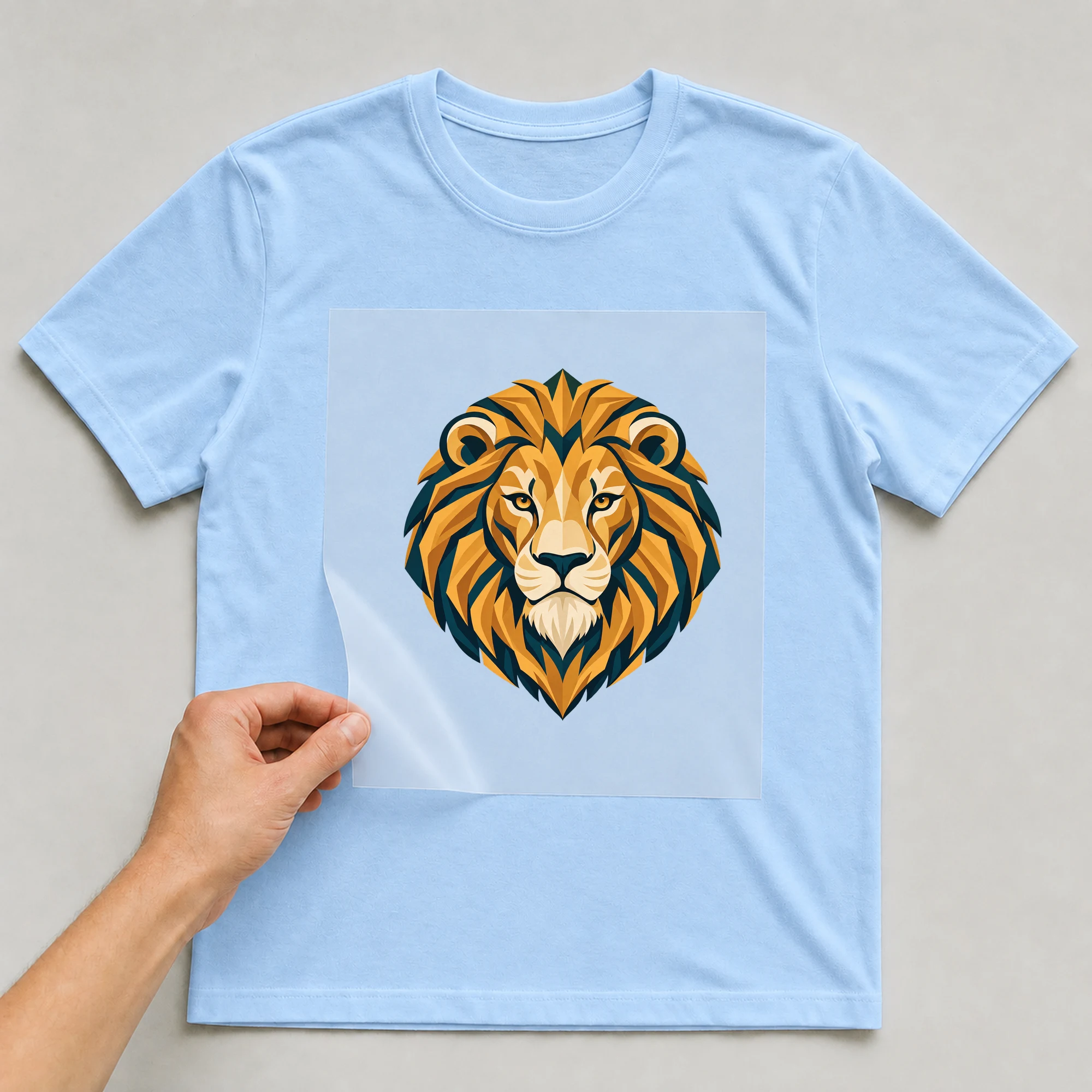 Bügelbild „Art Deco Sternzeichen Löwe“ auf babyblauem T-Shirt, Folie wird aufgelegt