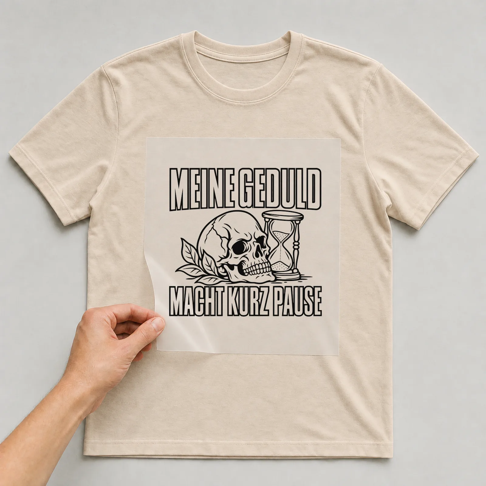 Bügelbild „Meine Geduld macht kurz Pause“ auf beigem T-Shirt, Folie wird aufgelegt