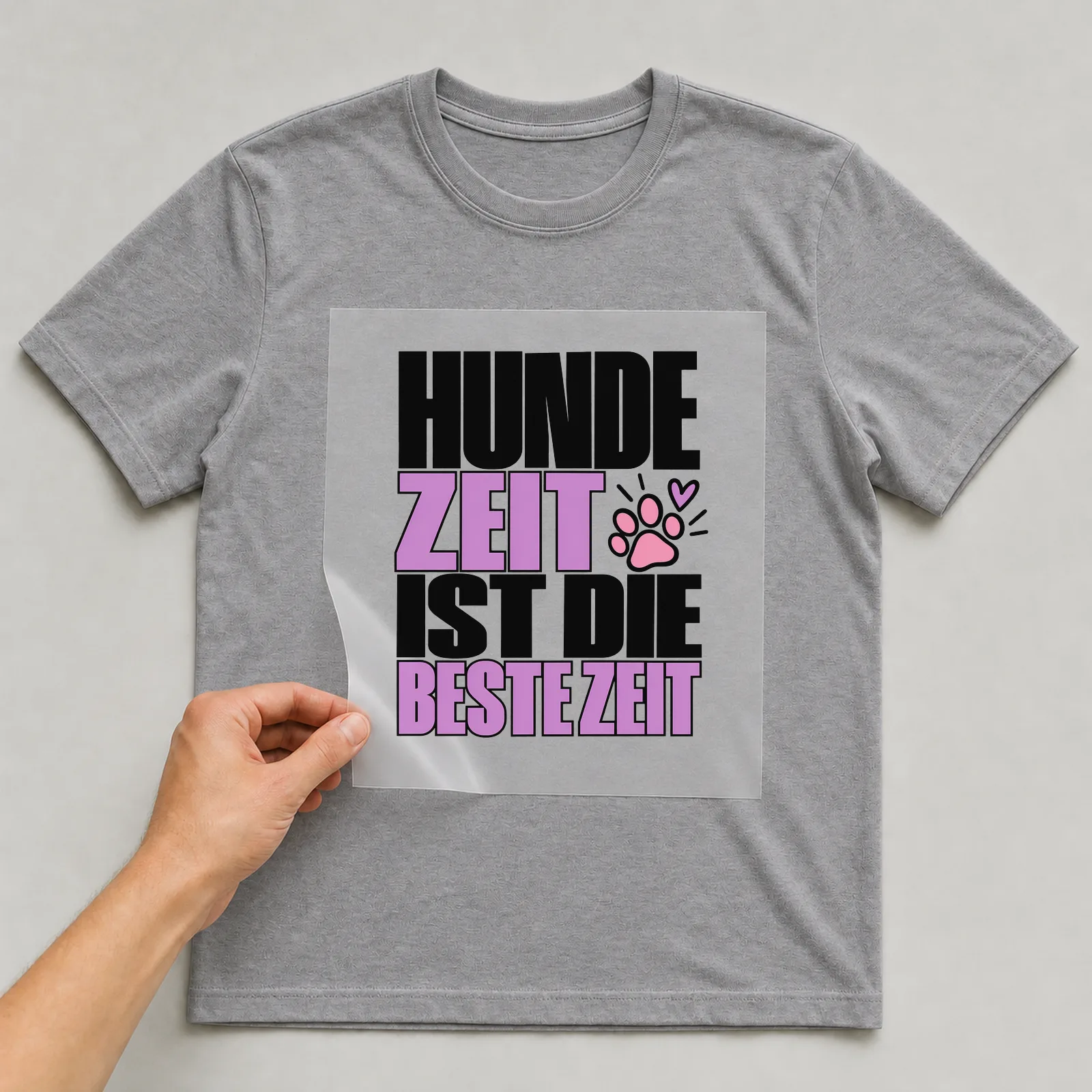 Bügelbild „Hundezeit ist die beste Zeit“ auf grauem T-Shirt, Folie wird aufgelegt