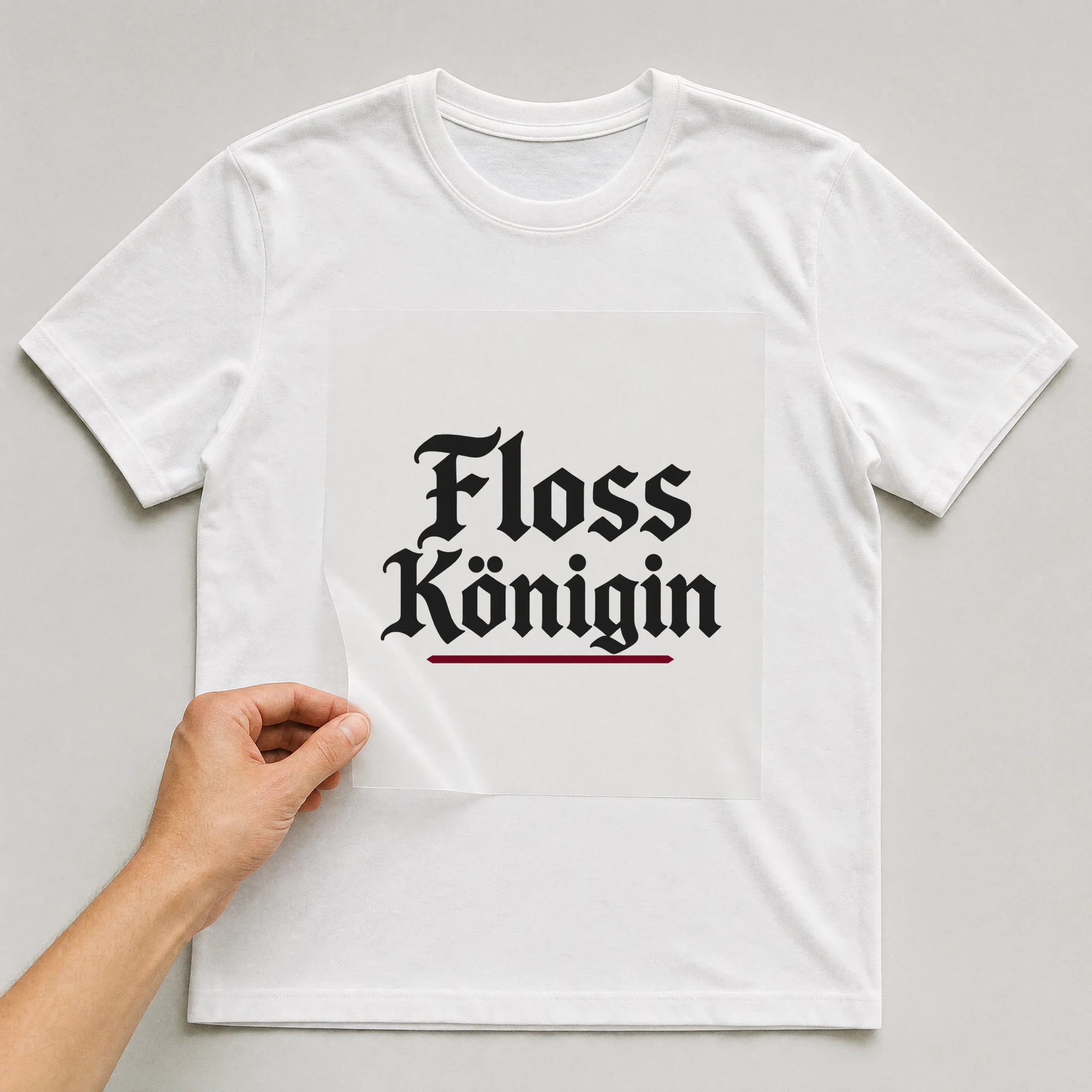 Bügelbild „Floss Königin“ auf weißem T-Shirt, Folie wird aufgelegt