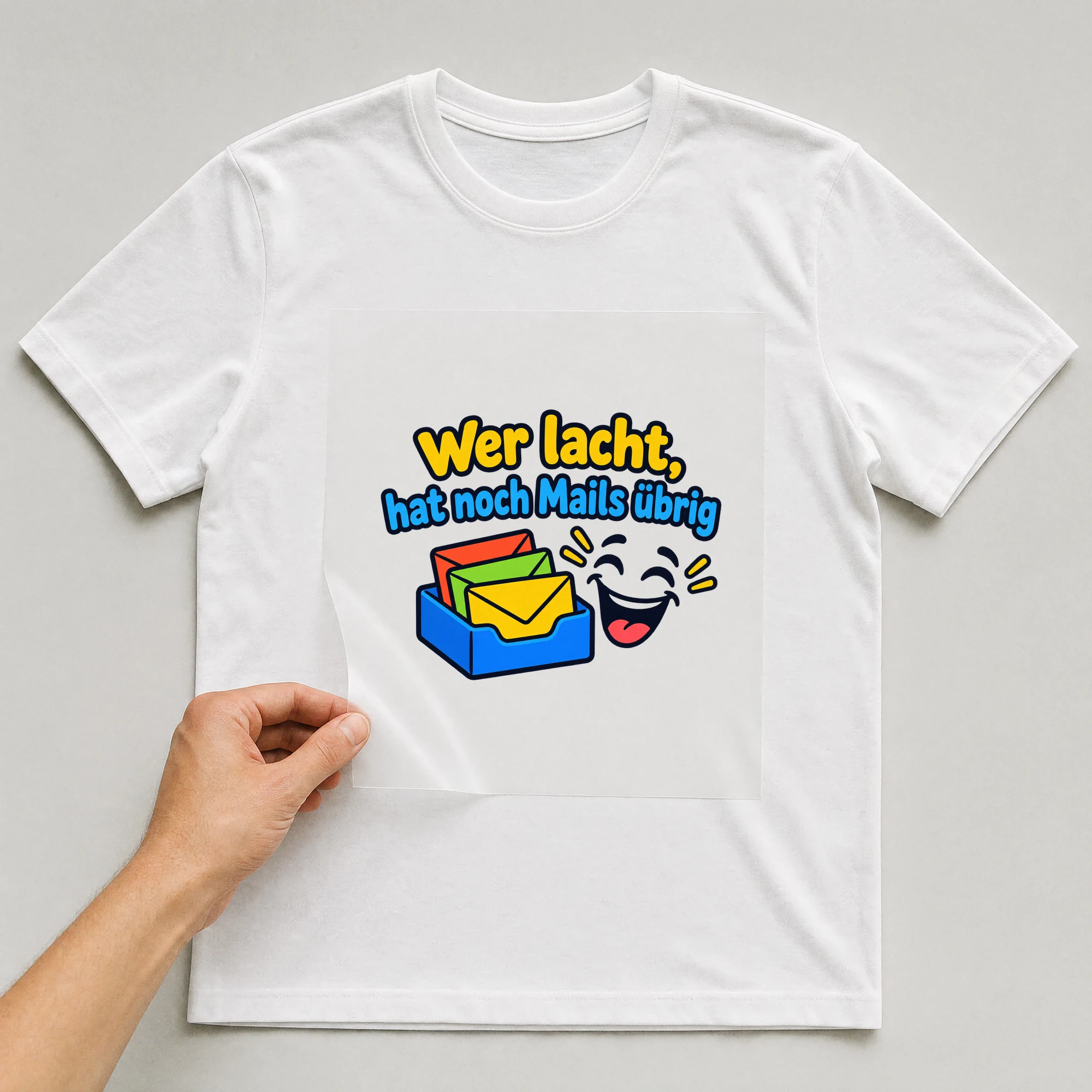 Bügelbild „Wer lacht, hat noch Mails übrig“ auf weißem T-Shirt, Folie wird aufgelegt