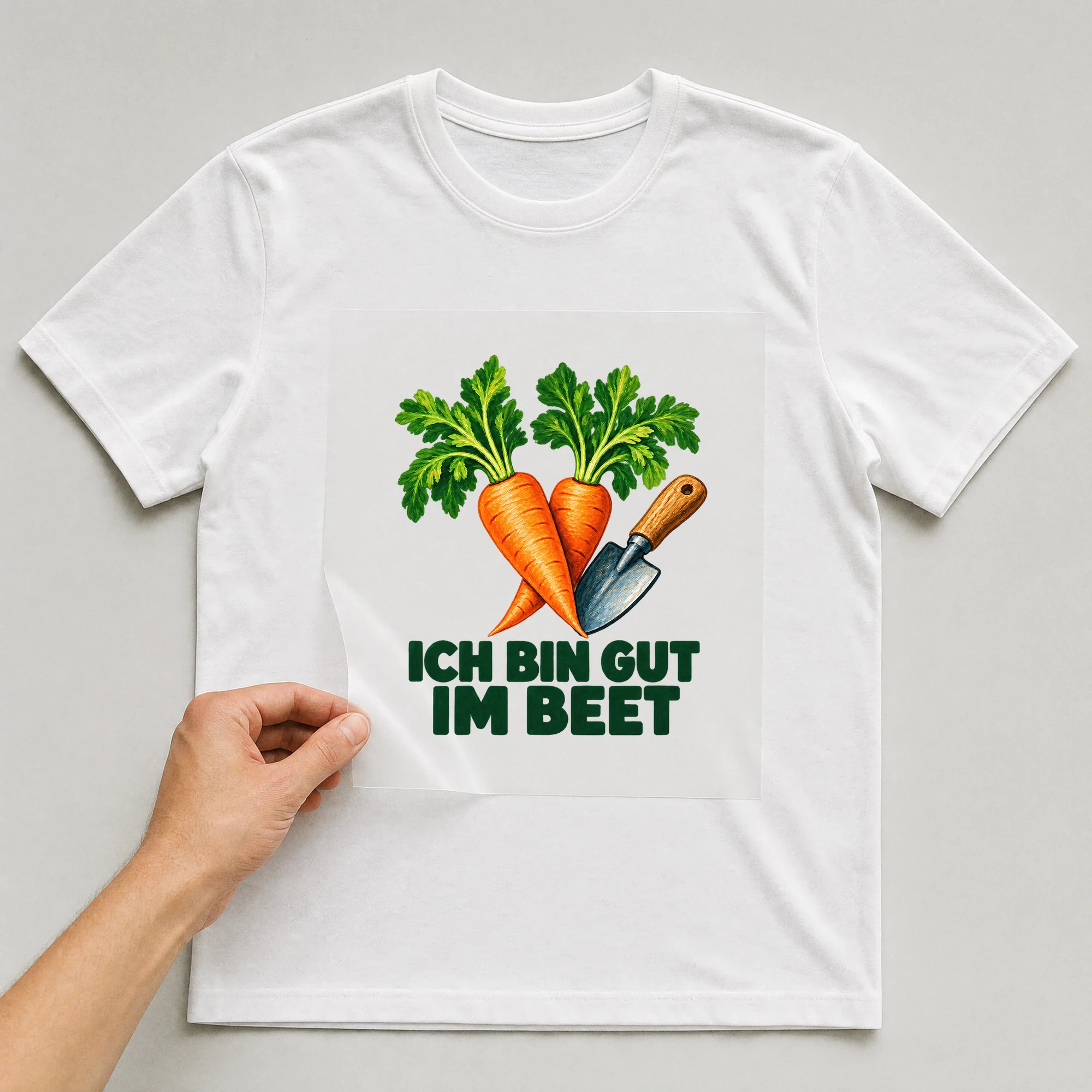 Bügelbild „Ich bin gut im Beet“ auf weißem T-Shirt, Folie wird aufgelegt