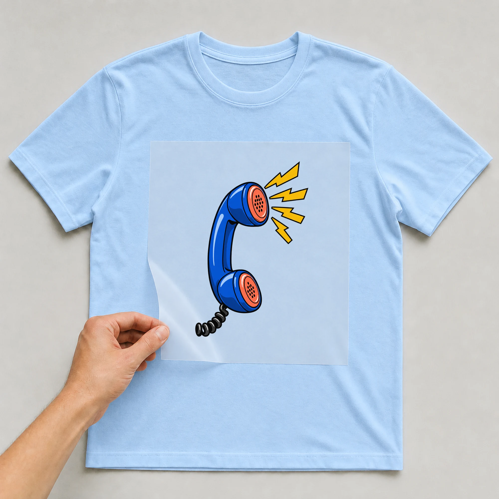 Bügelbild „Pop Art Telephone“ auf babyblauem T-Shirt, Folie wird aufgelegt
