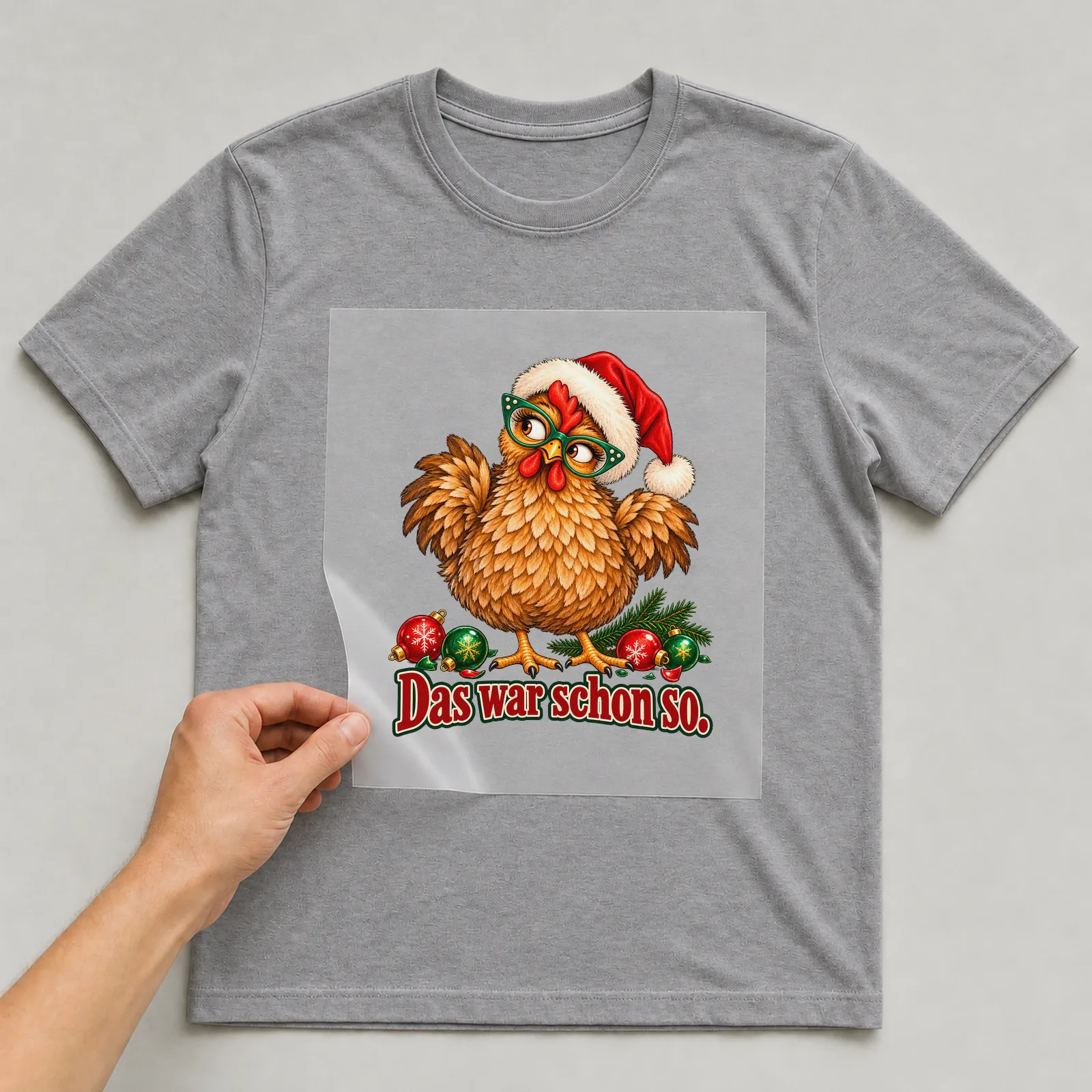 Bügelbild huhn baumkugelchaos auf grauem T-Shirt, Folie wird aufgelegt
