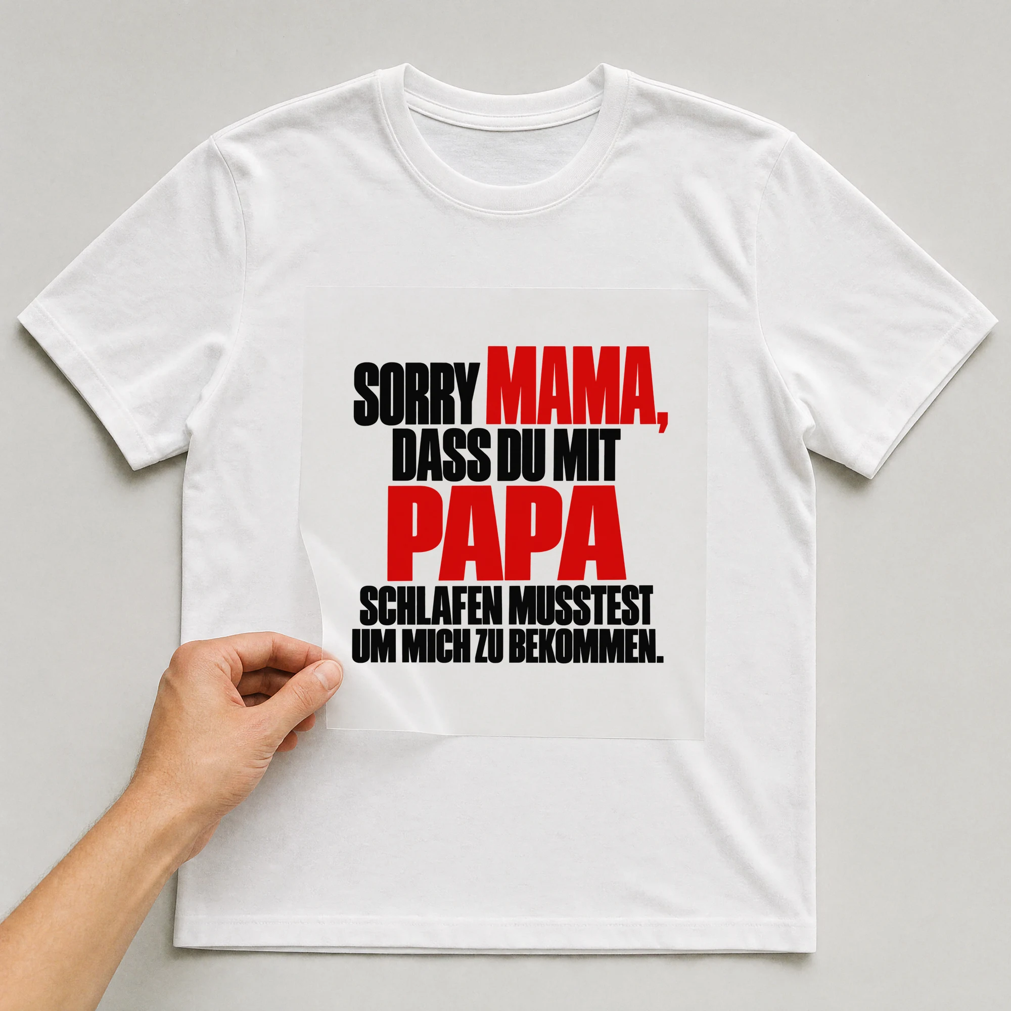 Bügelbild „Sorry Mama, dass du mit Papa schlafen musstest um mich zu bekommen.“ auf weißem T-Shirt, Folie wird aufgelegt
