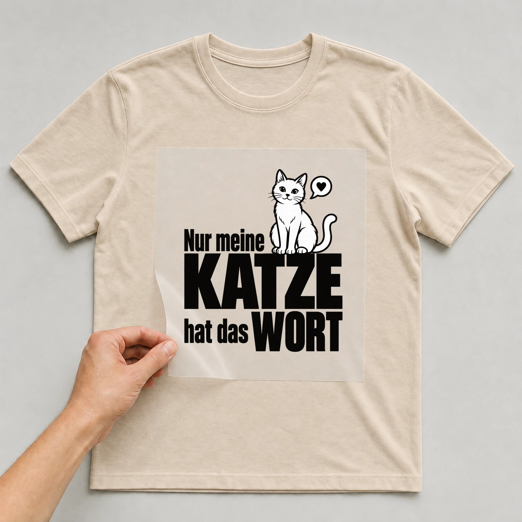 Bügelbild „Nur meine Katze hat das Wort“ auf beigem T-Shirt, Folie wird aufgelegt