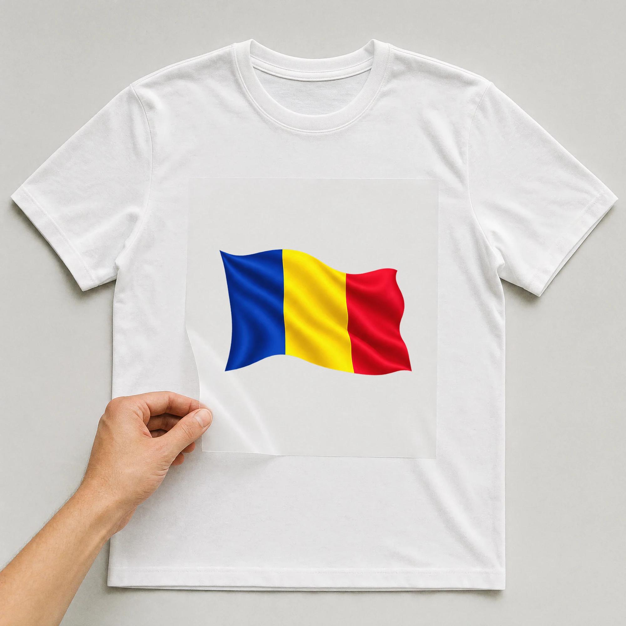 Bügelbild „Länder Flagge Rumänien“ auf weißem T-Shirt, Folie wird aufgelegt
