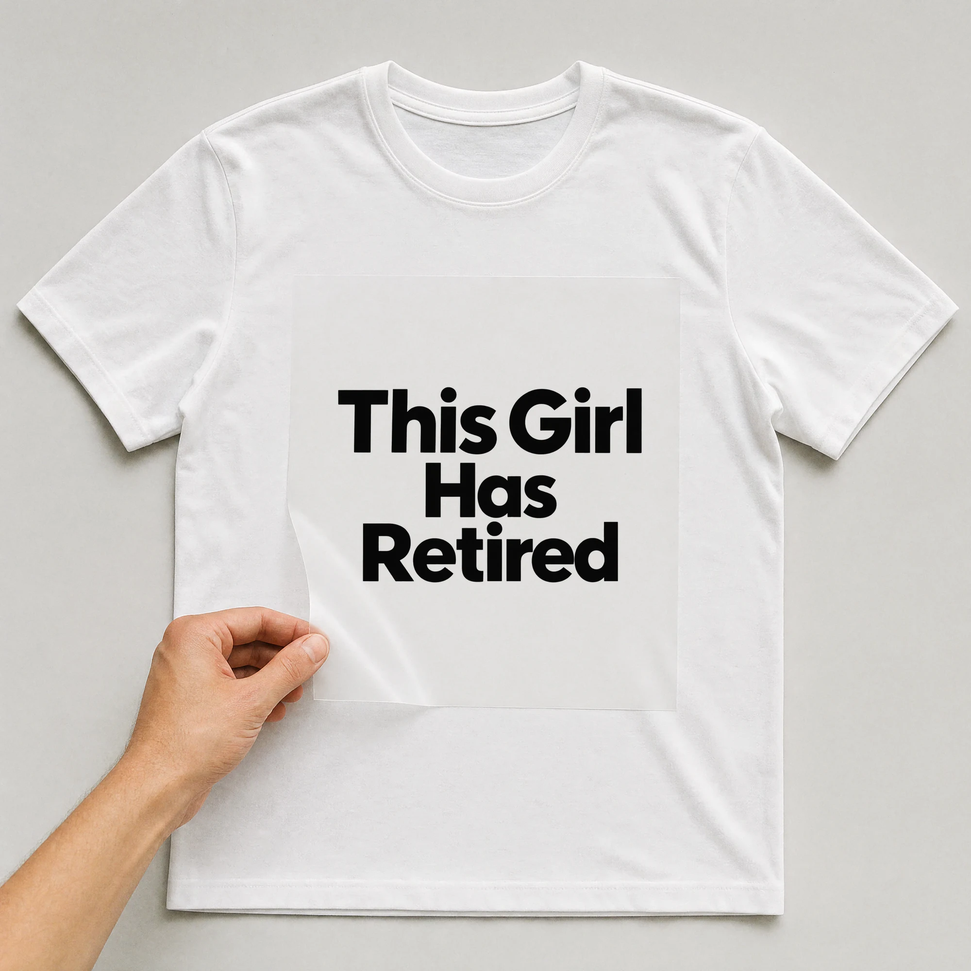 Bügelbild „This Girl Has Retired“ auf weißem T-Shirt, Folie wird aufgelegt