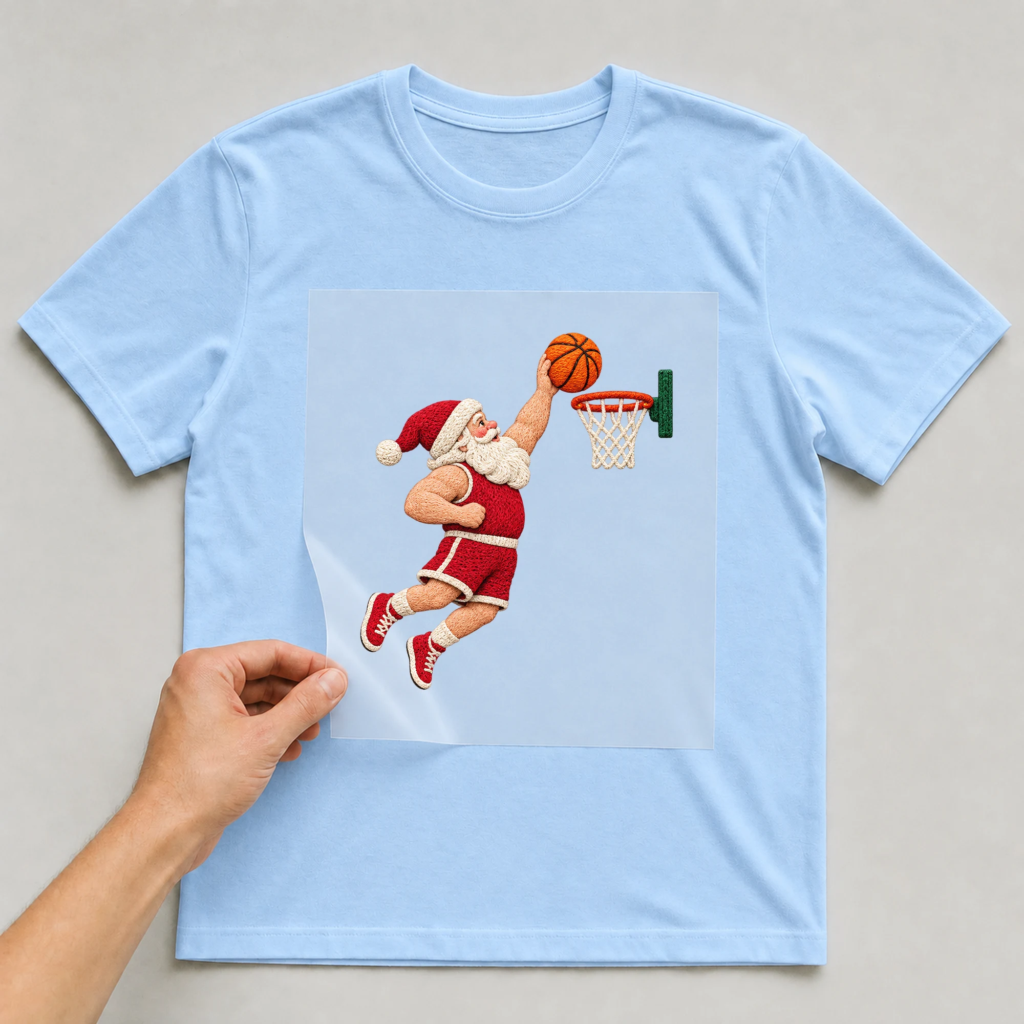 Bügelbild „Basketball Dunk Christmas“ auf babyblauem T-Shirt, Folie wird aufgelegt