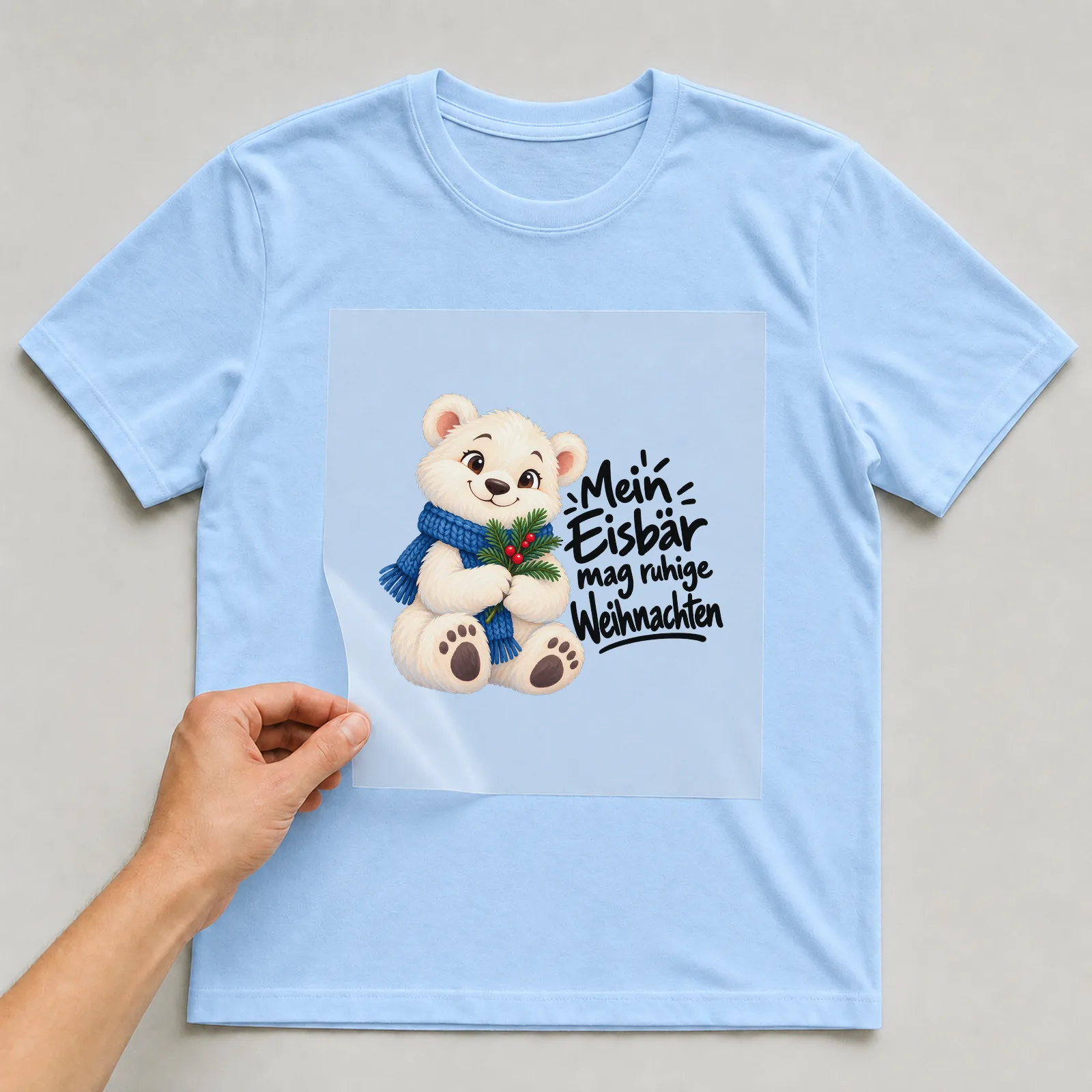 Bügelbild „Mein Eisbär mag ruhige Weihnachten“ auf hellblauem T-Shirt, Folie wird aufgelegt