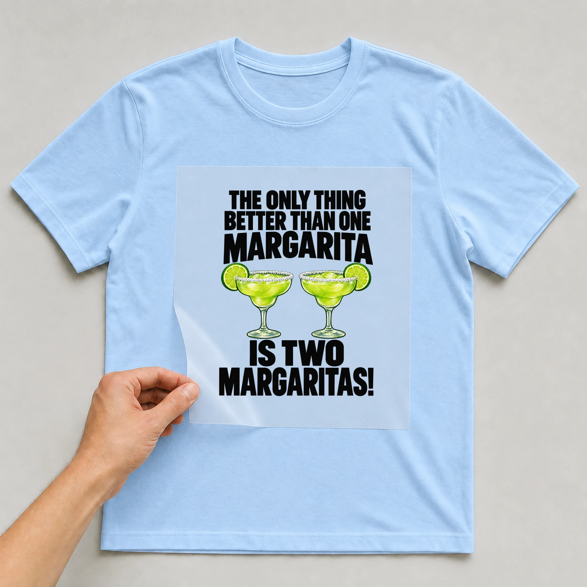 Bügelbild „The Only Thing Better Than One Margarita Is Two Margaritas!“ auf babyblauem T-Shirt, Folie wird aufgelegt