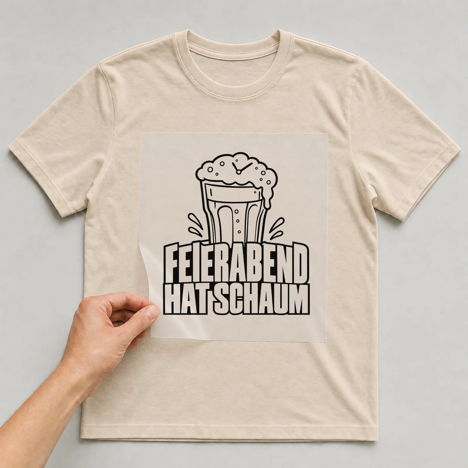 Bügelbild „Feierabend hat Schaum“ auf beigem T-Shirt, Folie wird aufgelegt