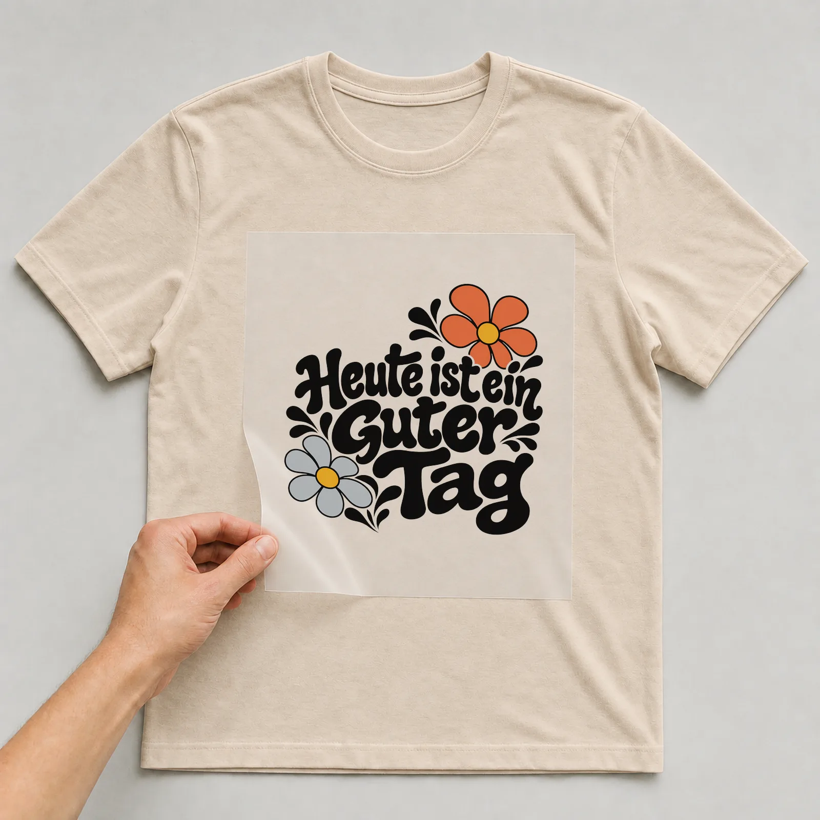 Bügelbild „Heute ist ein guter Tag“ auf beigem T-Shirt, Folie wird aufgelegt