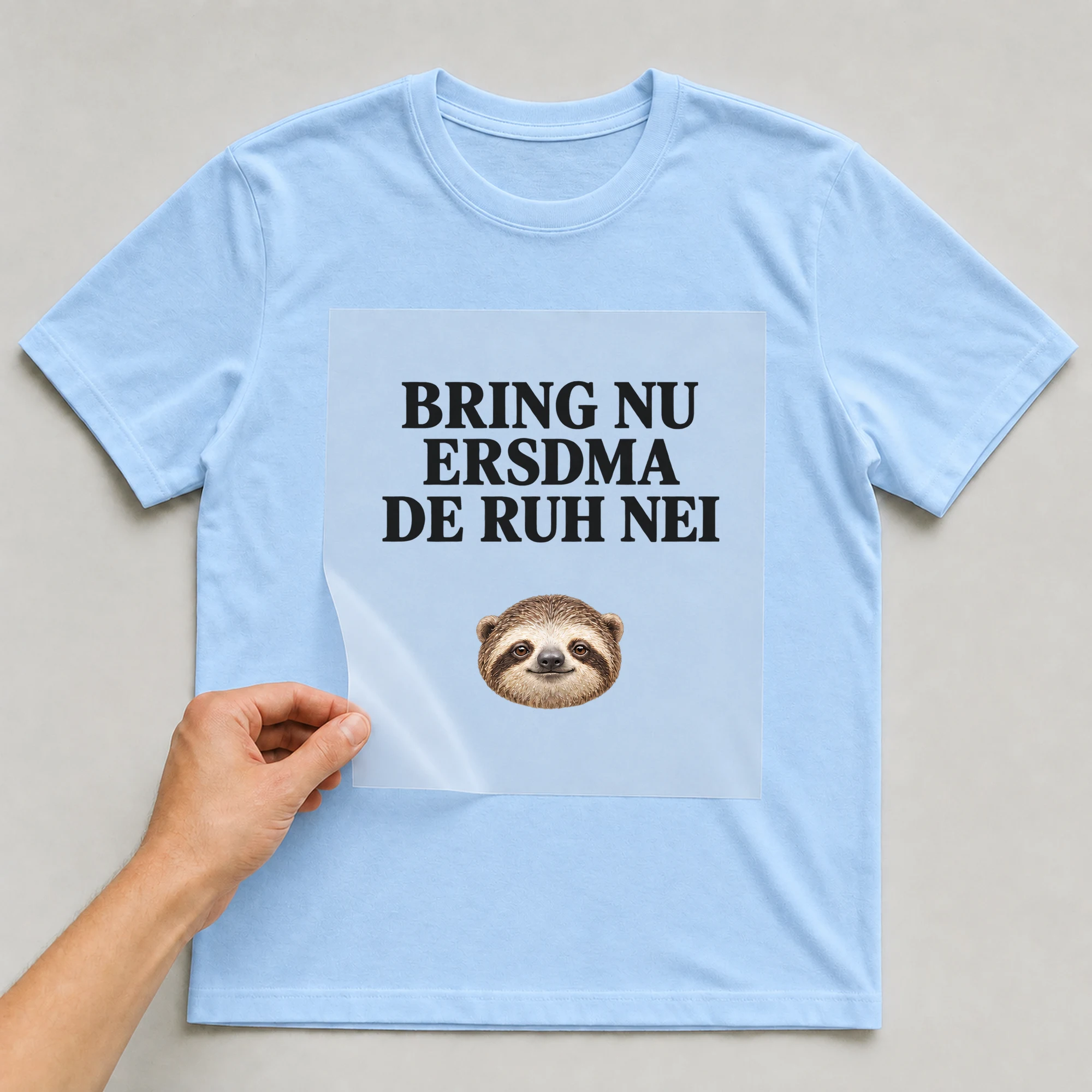 Bügelbild „BRING NU ERSDMA DE RUH NEI“ auf babyblauem T-Shirt, Folie wird aufgelegt