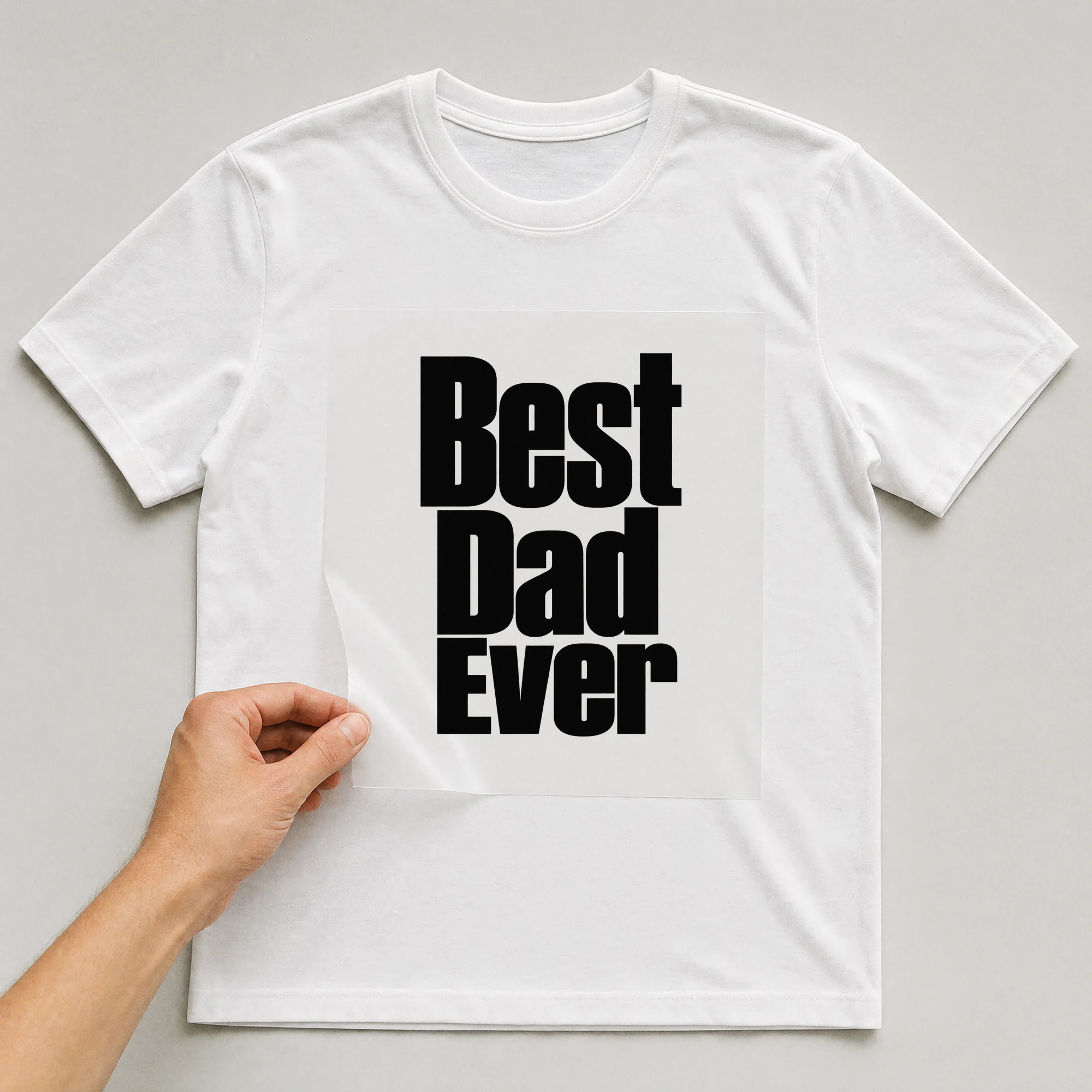 Bügelbild „Best Dad Ever“ auf weißem T-Shirt, Folie wird aufgelegt