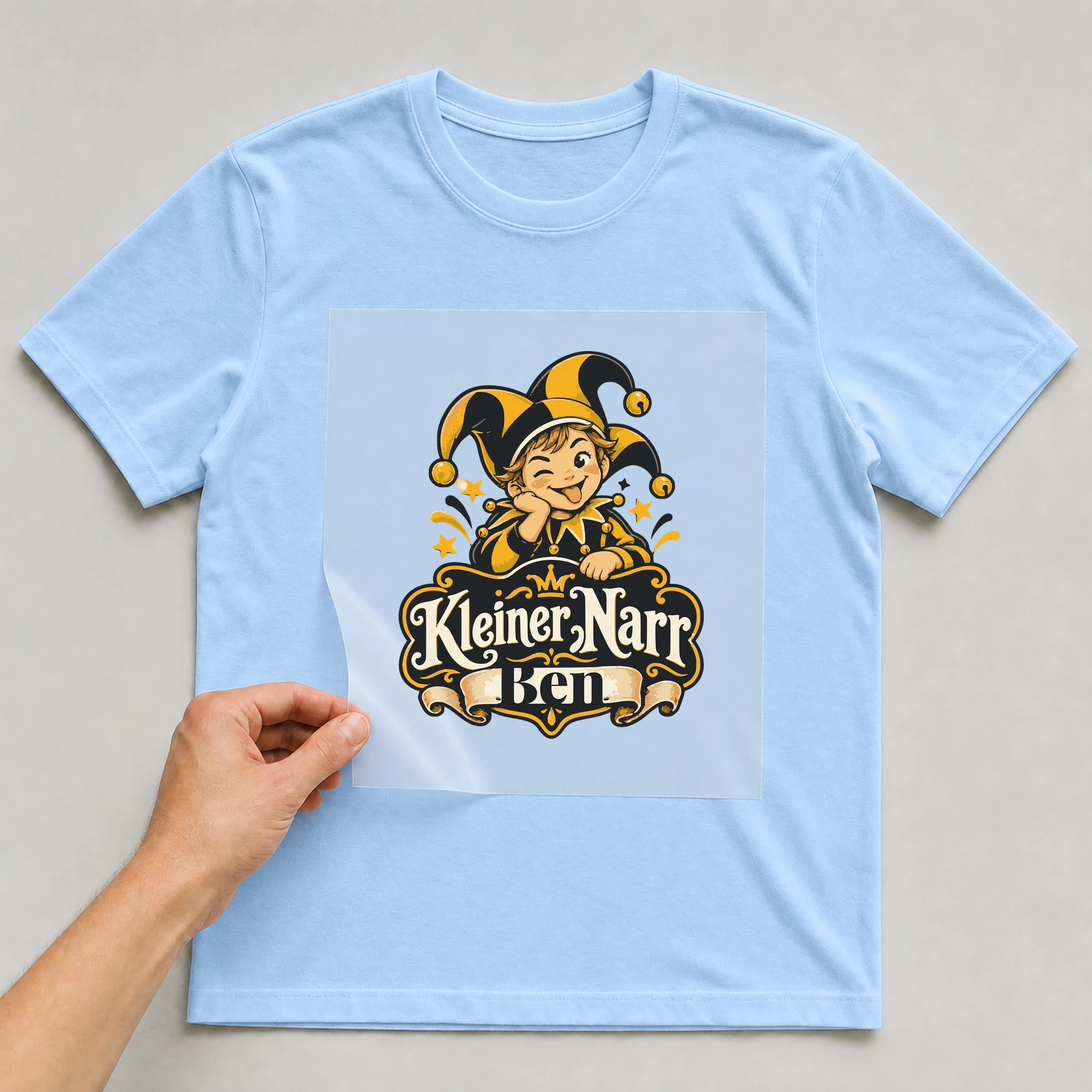 Bügelbild Kleiner Narr mit Name auf hellblauem T-Shirt, Folie wird aufgelegt
