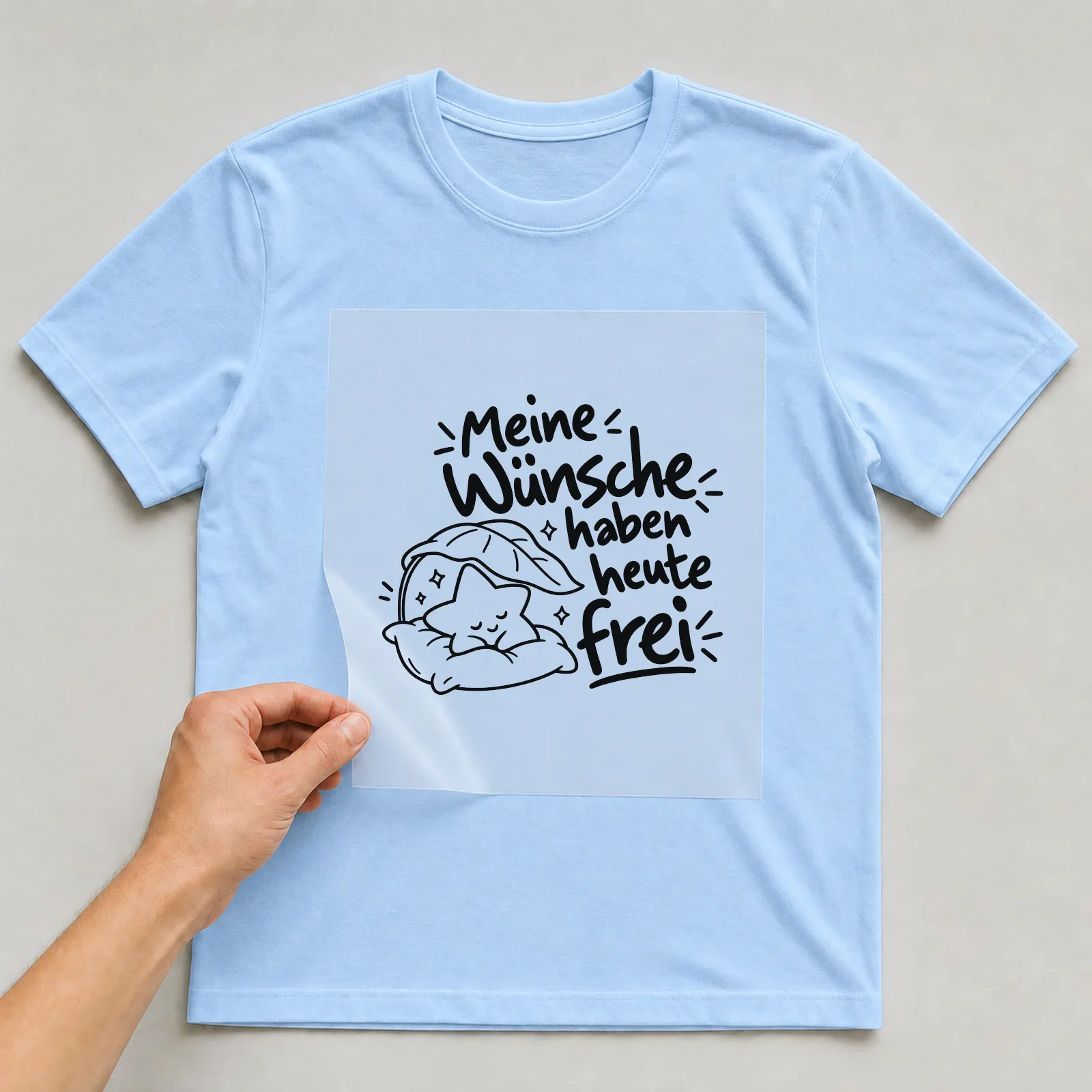 Bügelbild „Meine Wünsche haben heute frei“ auf hellblauem T-Shirt, Folie wird aufgelegt