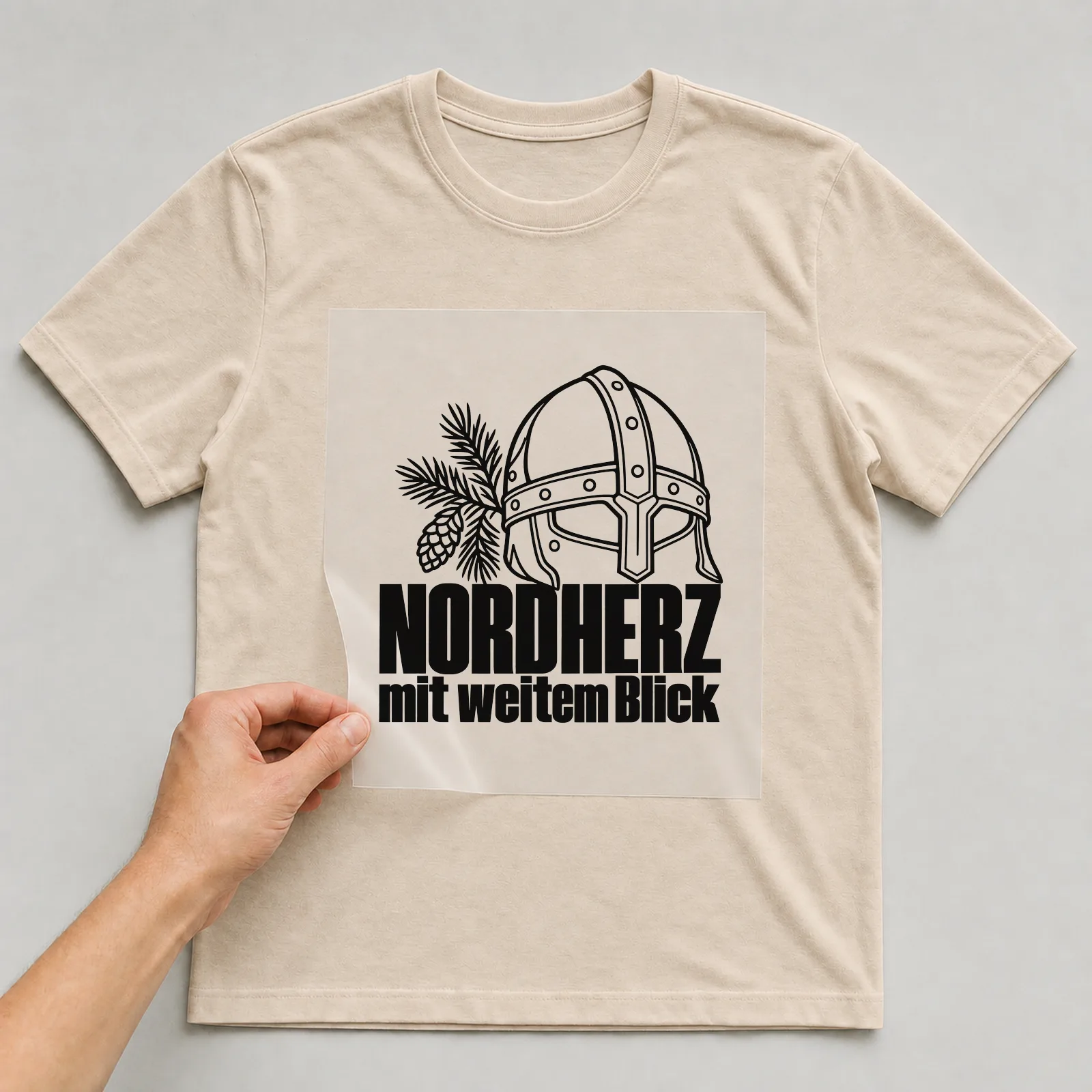 Bügelbild „Nordherz mit weitem Blick“ auf beigem T-Shirt, Folie wird aufgelegt