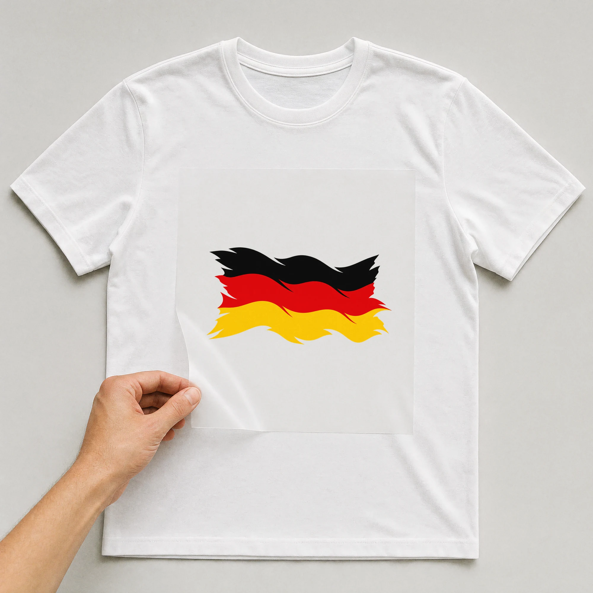 Bügelbild „Zerrissene Fahne Deutschland“ auf weißem T-Shirt, Folie wird aufgelegt