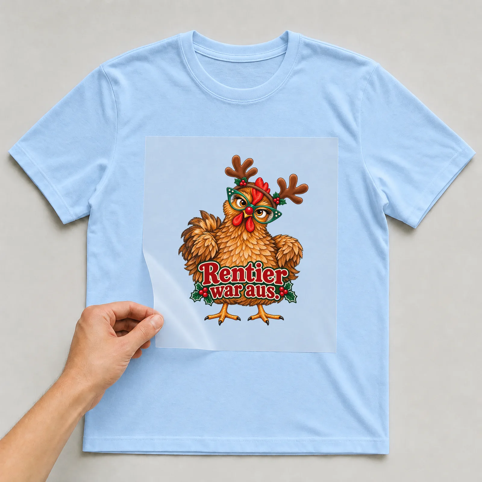 Bügelbild huhn rentier war aus auf hellblauem T-Shirt, Folie wird aufgelegt