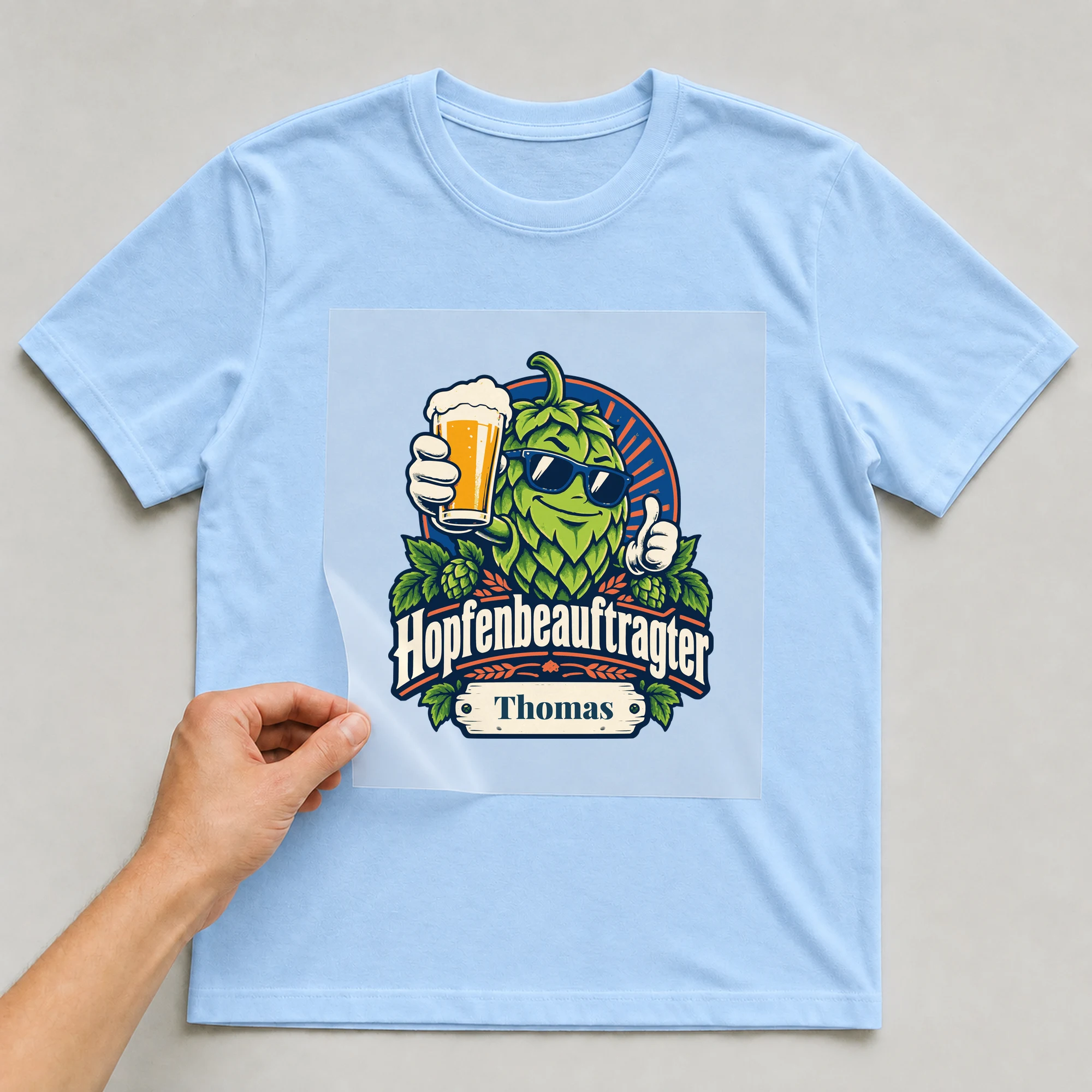 Bügelbild Hopfenbeauftragter mit Name auf hellblauem T-Shirt, Folie wird aufgelegt