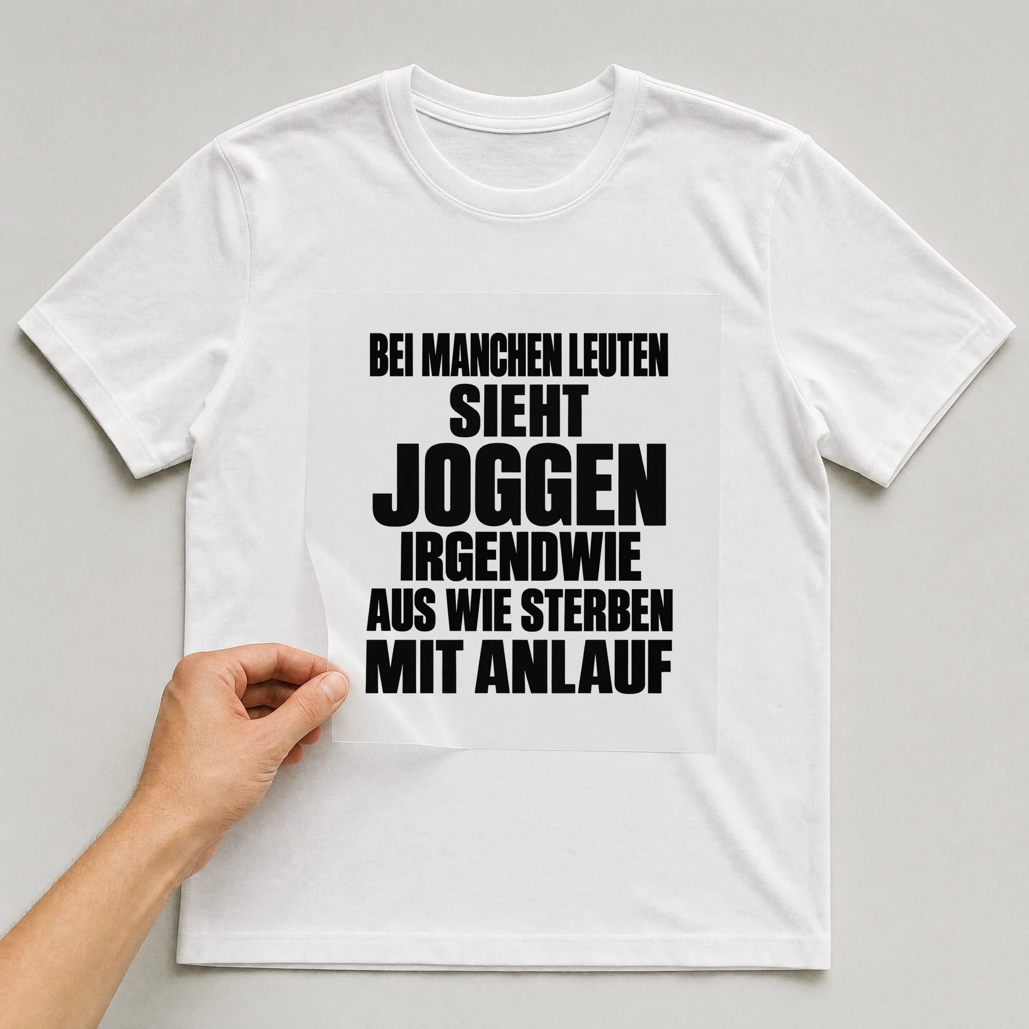 Bügelbild „Bei manchen Leuten sieht joggen irgendwie aus wie sterben mit Anlauf“ auf weißem T-Shirt, Folie wird aufgelegt