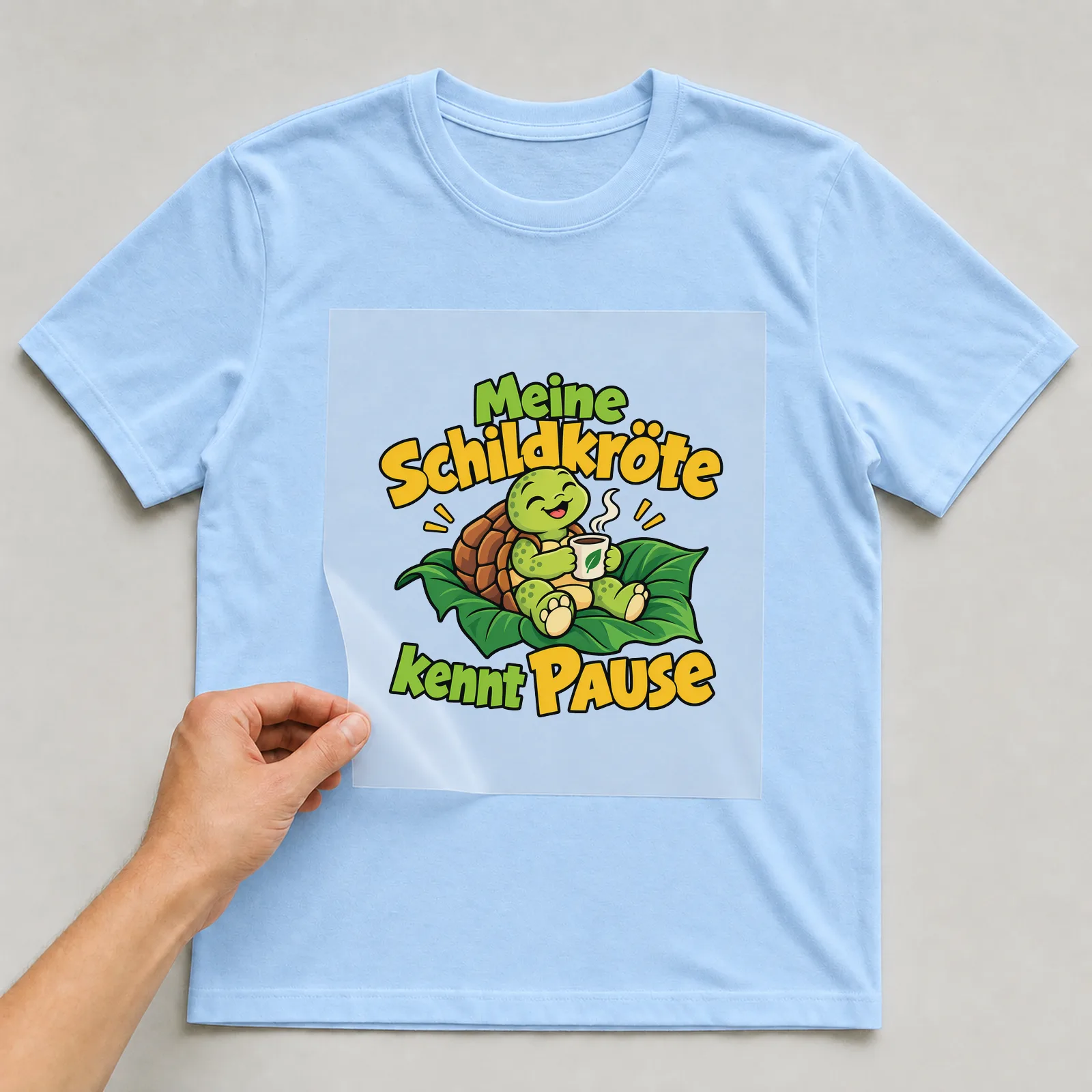 Bügelbild „Meine Schildkröte kennt Pause“ auf hellblauem T-Shirt, Folie wird aufgelegt