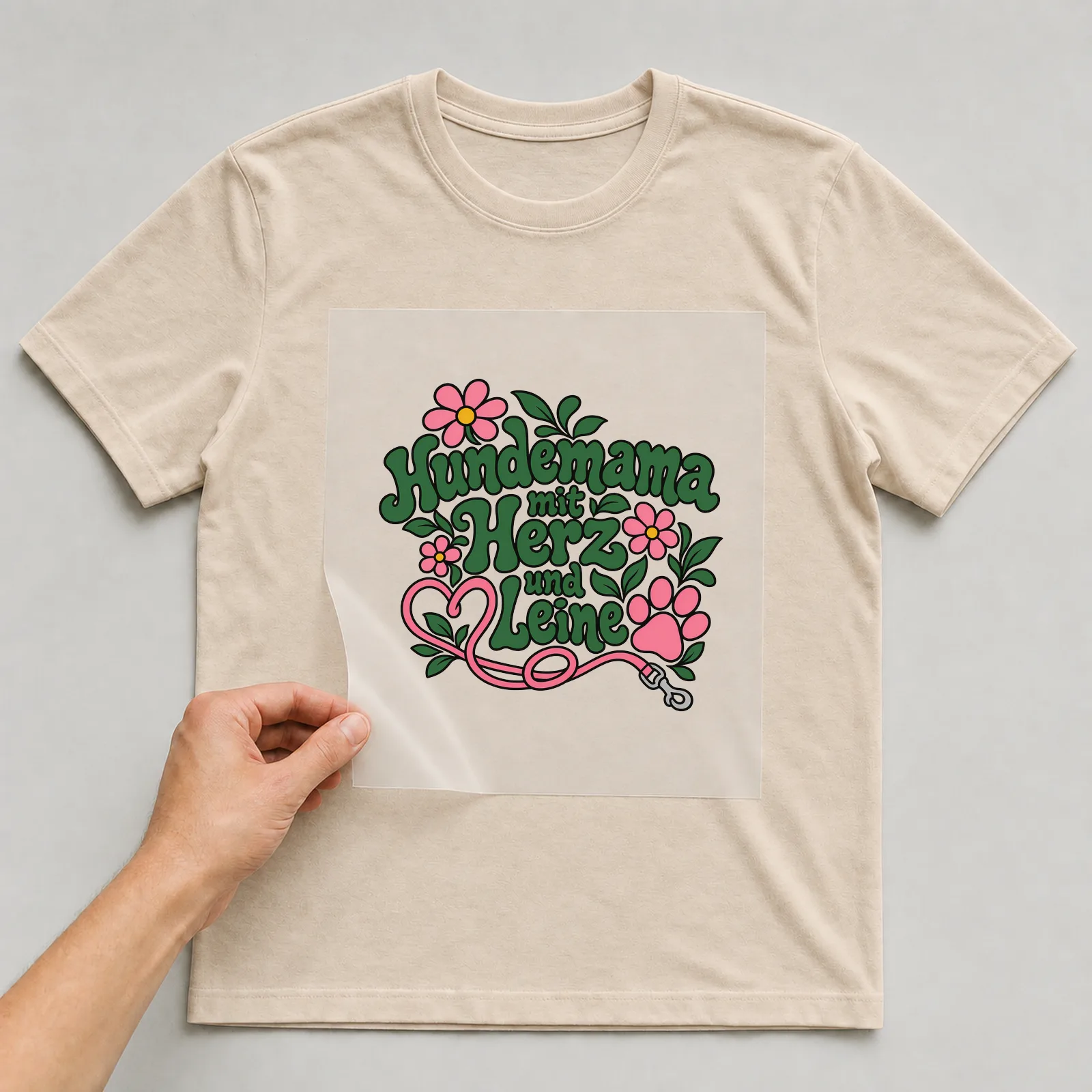 Bügelbild „Hundemama mit Herz und Leine“ auf beigem T-Shirt, Folie wird aufgelegt
