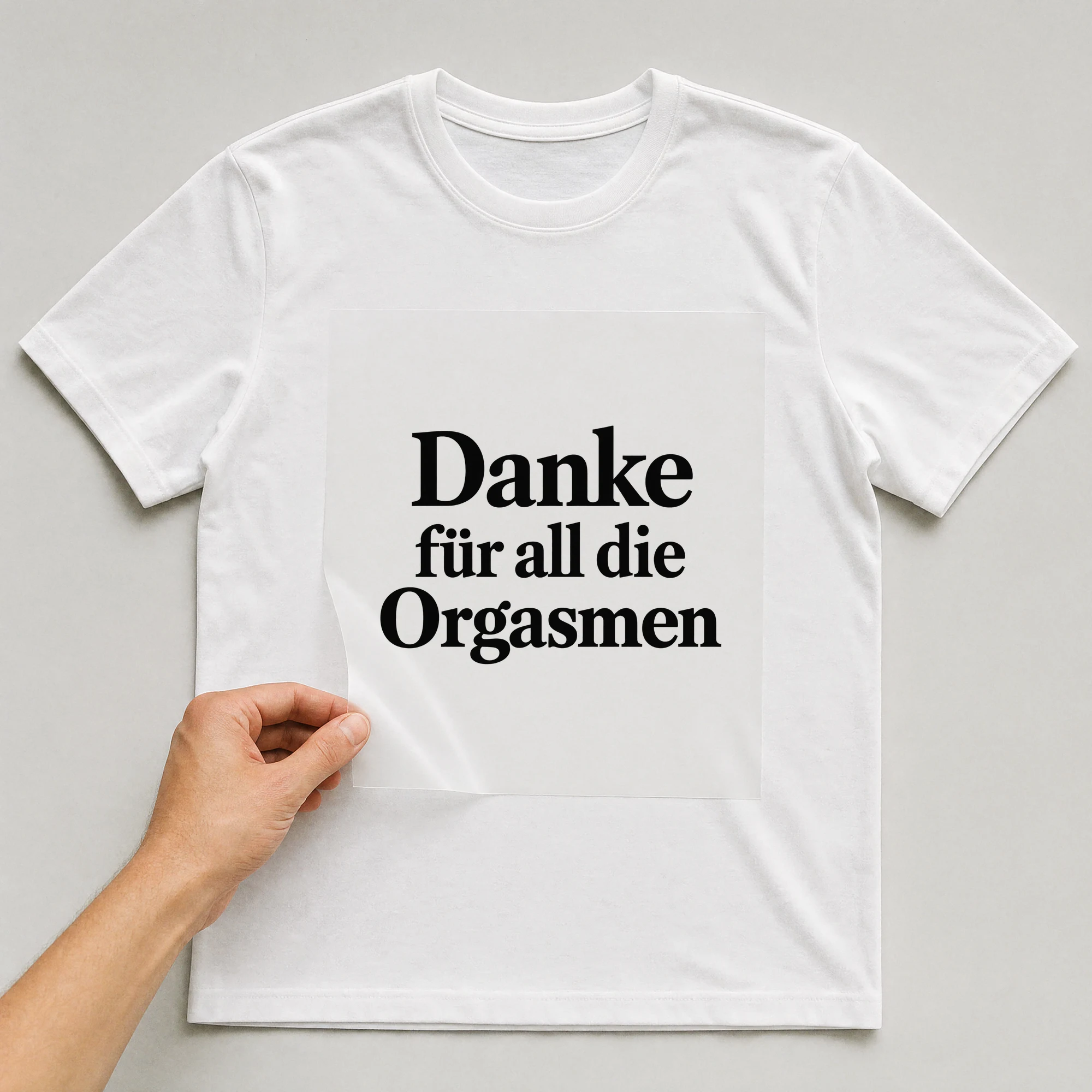 Bügelbild „Danke für all die Orgasmen“ auf weißem T-Shirt, Folie wird aufgelegt