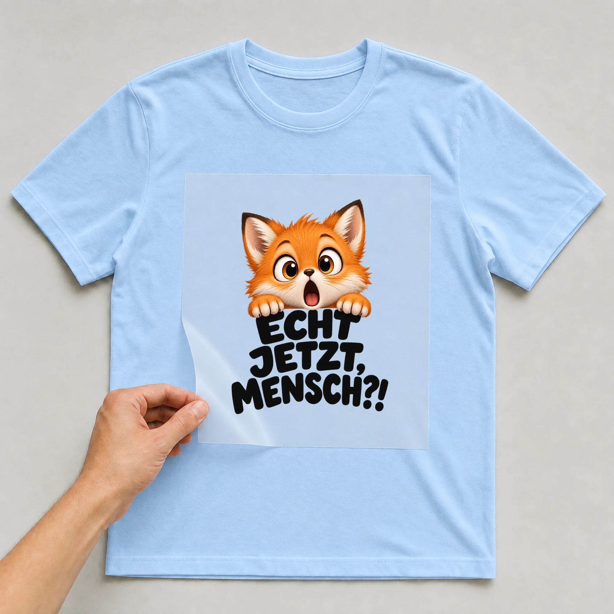 Bügelbild „Echt jetzt, Mensch?!“ auf babyblauem T-Shirt, Folie wird aufgelegt