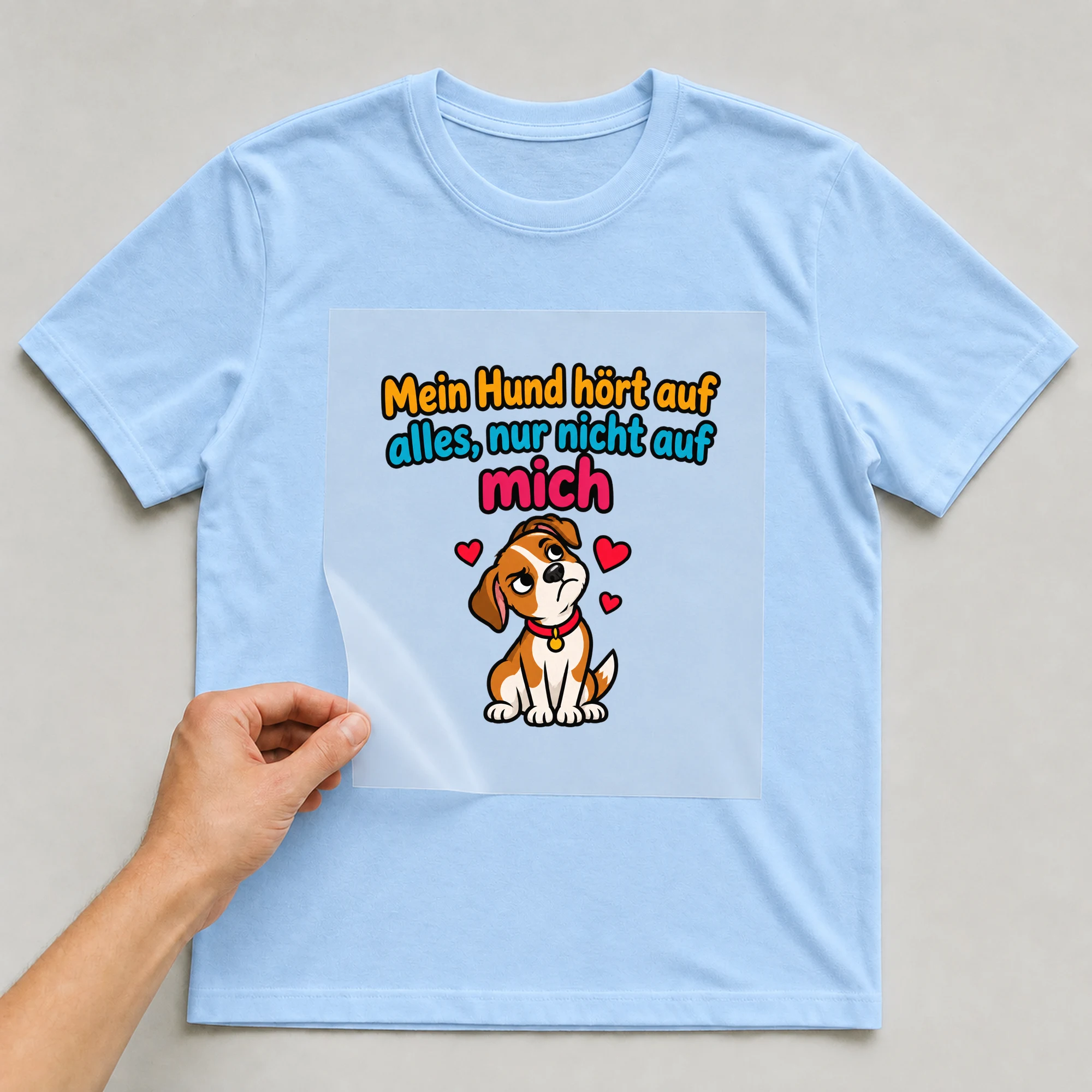 Bügelbild „Mein Hund hört auf alles, nur nicht auf mich“ auf babyblauem T-Shirt, Folie wird aufgelegt