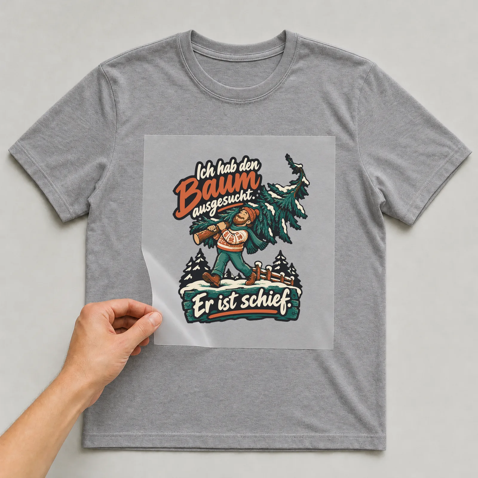 Bügelbild Ich hab den Baum ausgesucht. Er ist schief. auf grauem T-Shirt, Folie wird aufgelegt