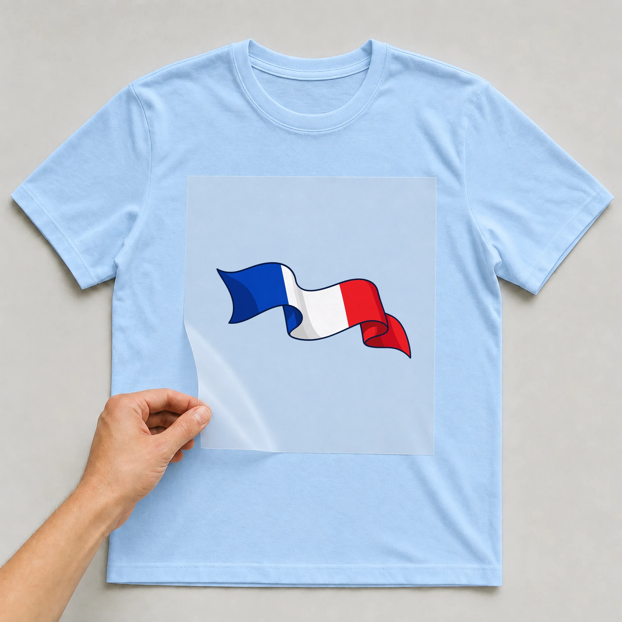 Bügelbild „Frankreich Fahne“ auf babyblauem T-Shirt, Folie wird aufgelegt