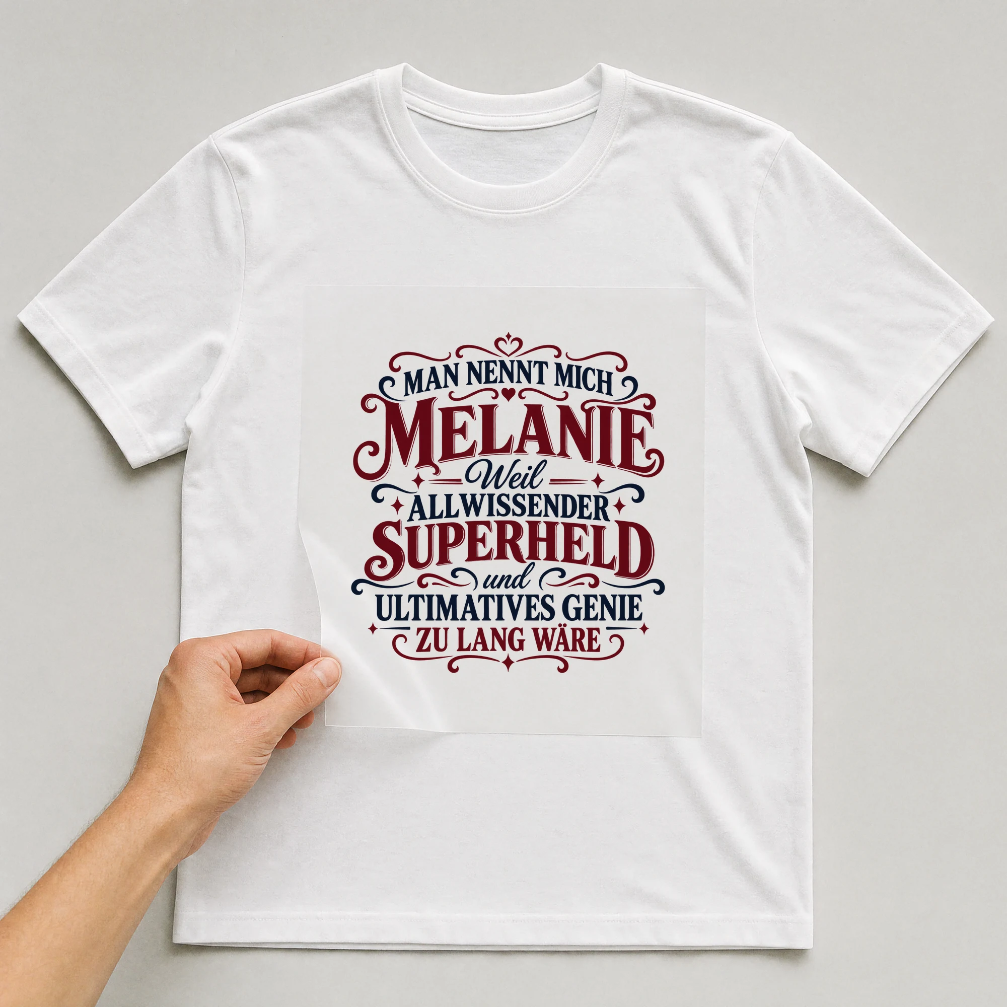 Bügelbild „Man nennt mich Melanie weil allwissender Superheld und ultimatives Genie zu“ auf weißem T-Shirt, Folie wird aufgelegt