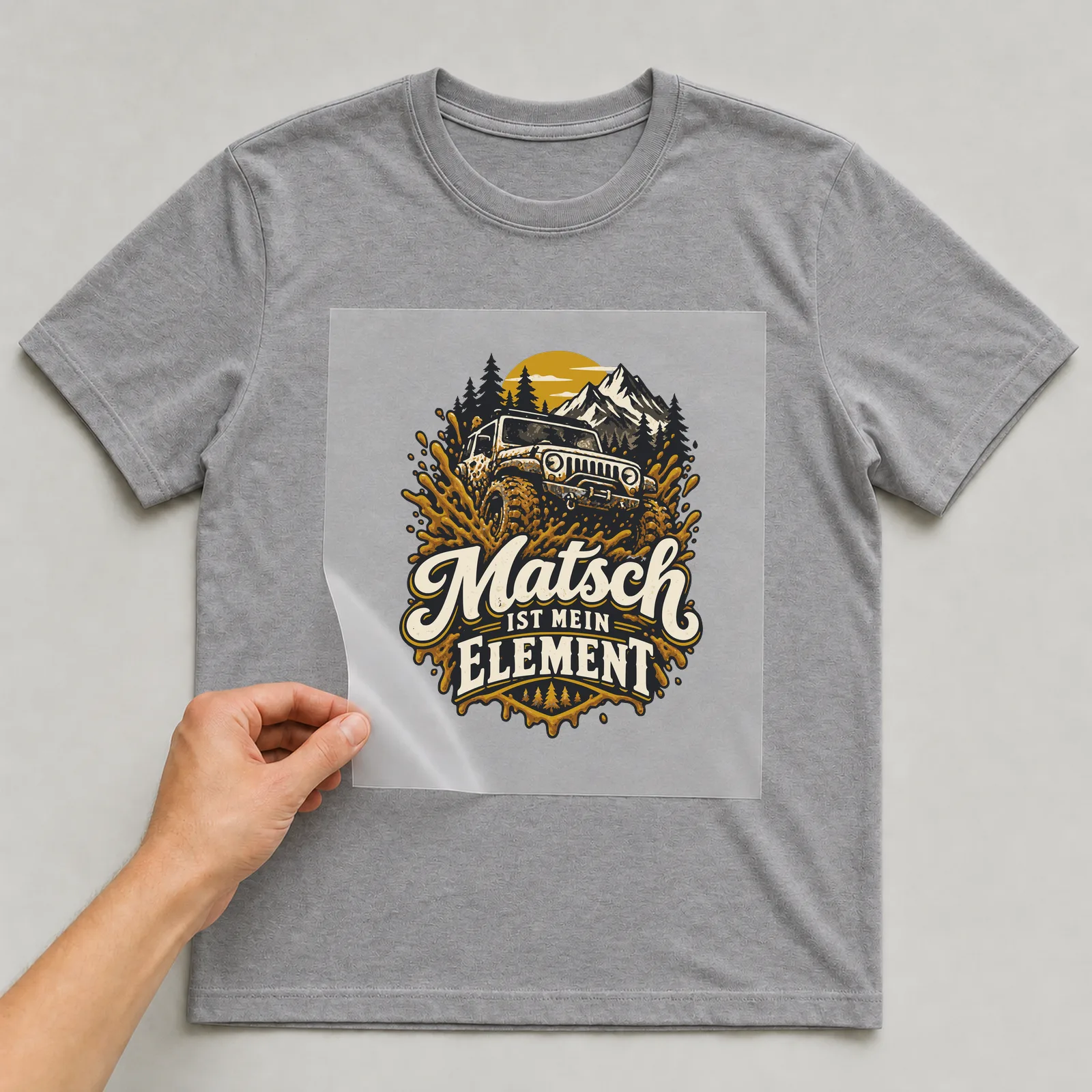 Bügelbild Matsch ist mein Element auf grauem T-Shirt, Folie wird aufgelegt