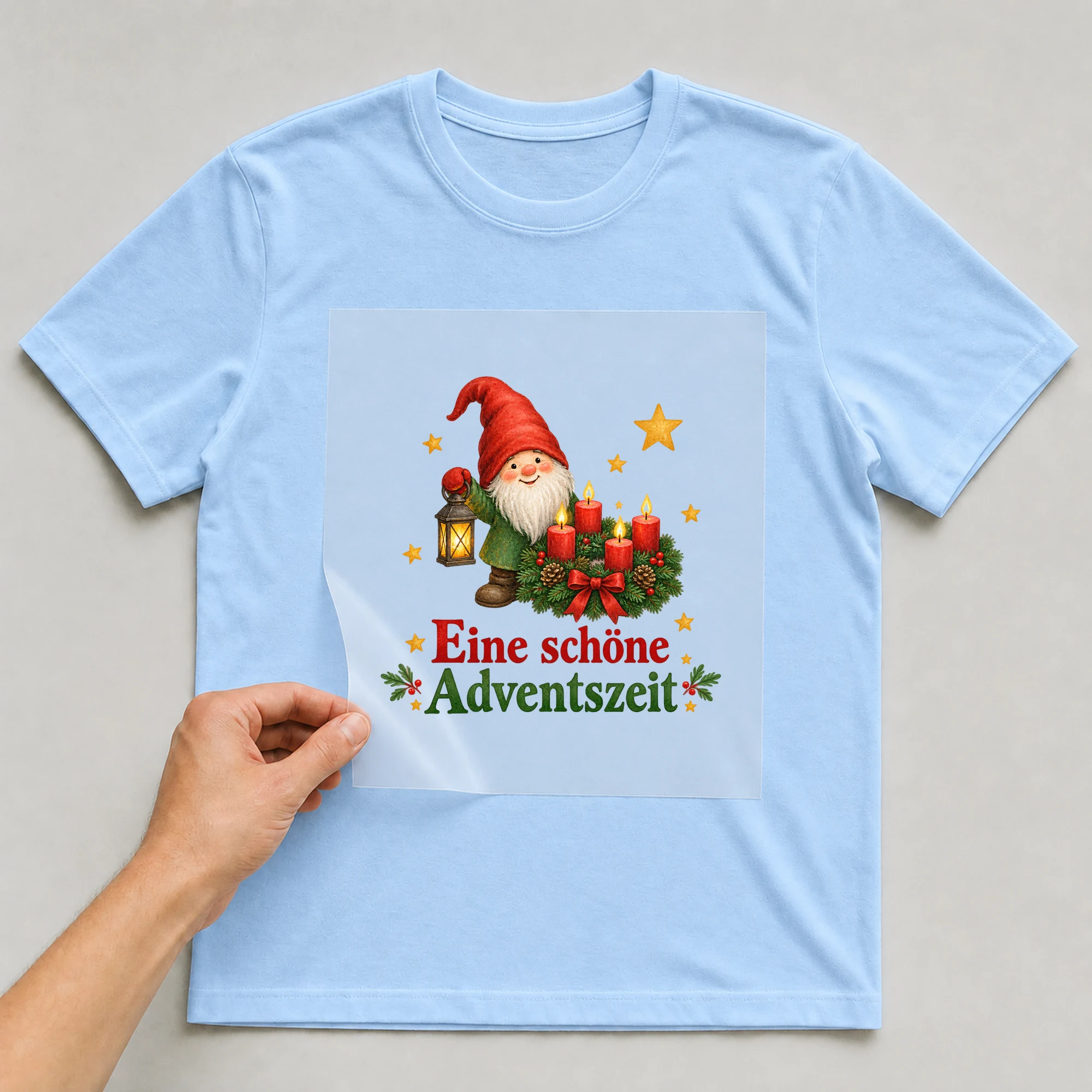 Bügelbild „Eine schöne Adventszeit“ auf babyblauem T-Shirt, Folie wird aufgelegt